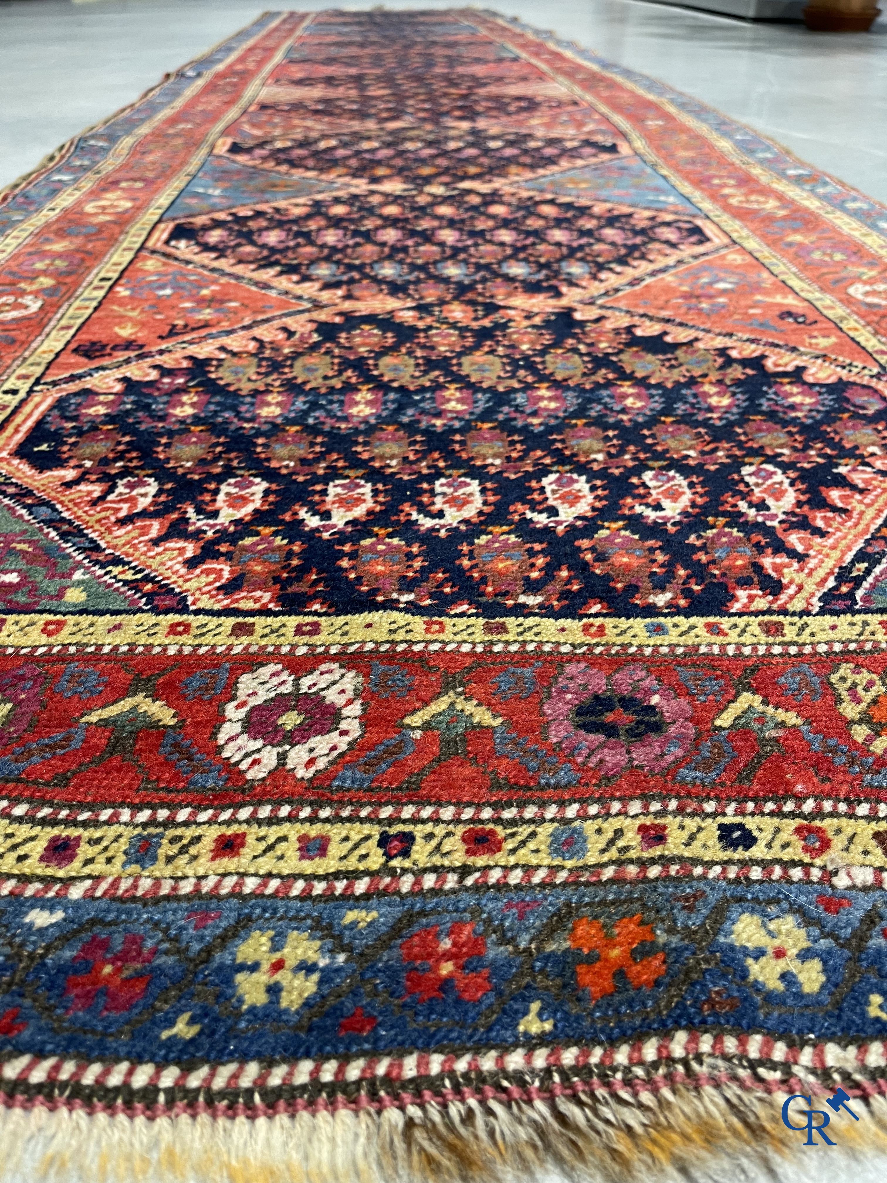Oriental carpets. A large hand-knotted antique runner with geometric motifs. 19th century.