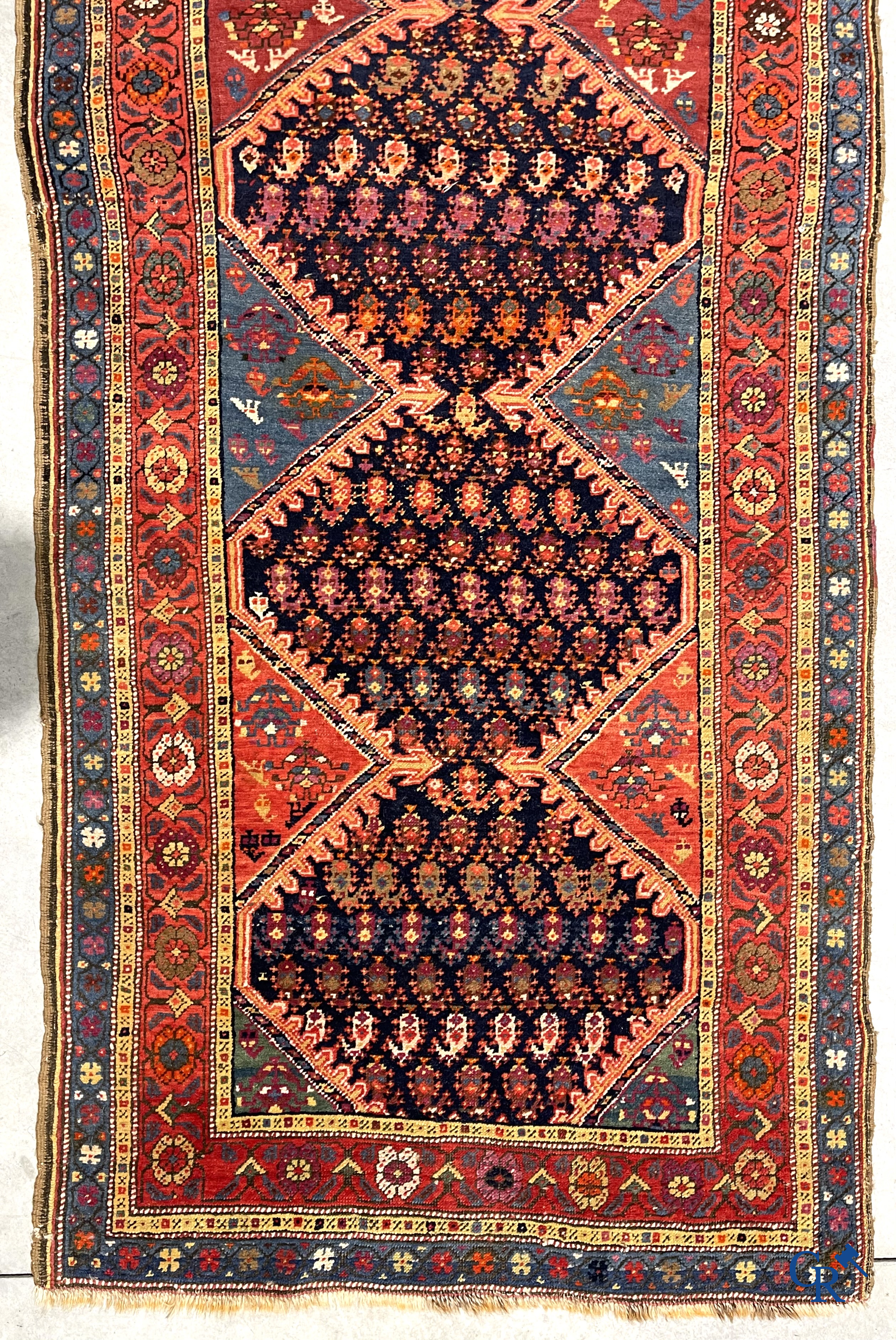 Oriental carpets. A large hand-knotted antique runner with geometric motifs. 19th century.