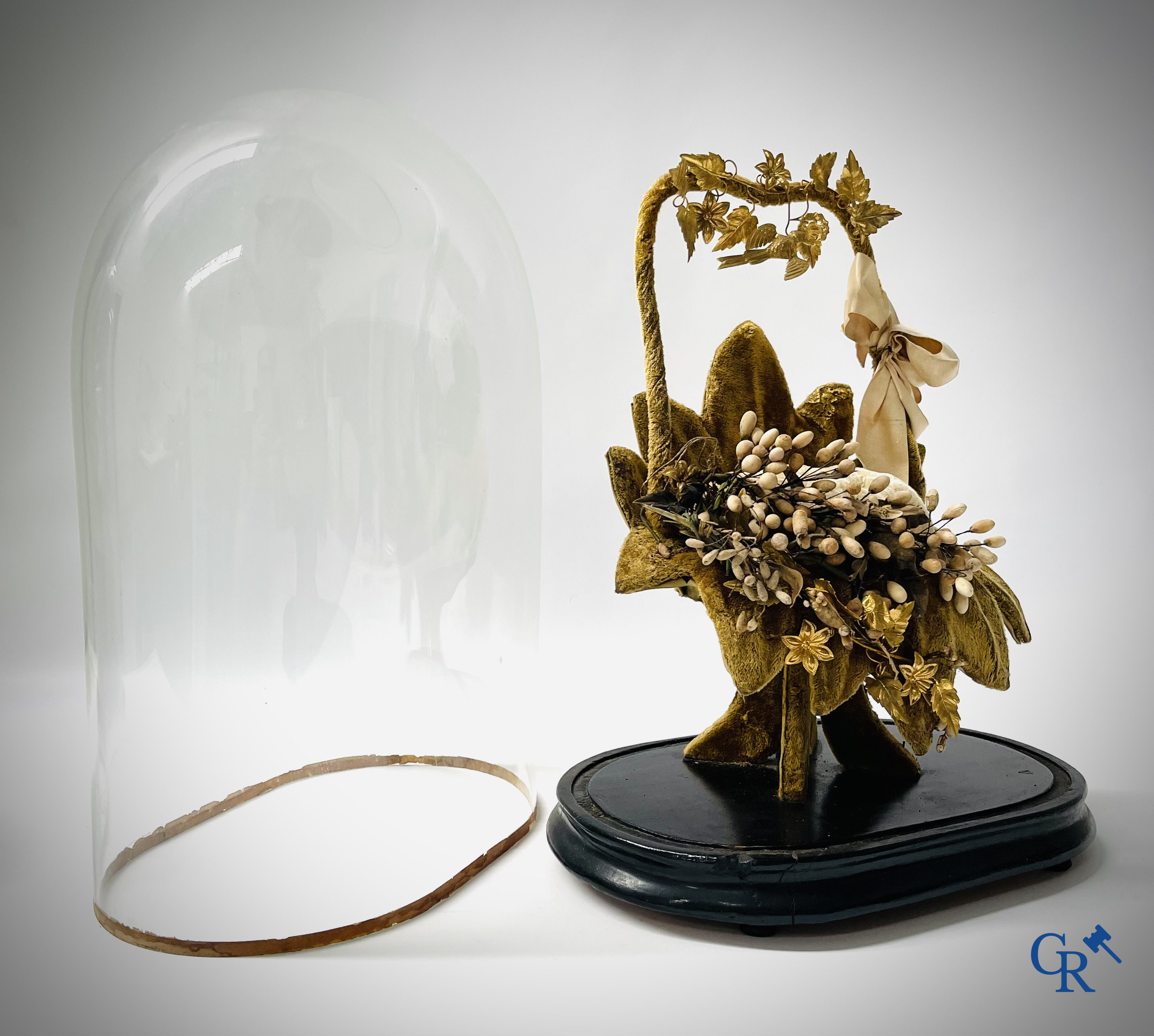 2 globes in glas met een bruidsboeket op sokkel bewerkt met ornamenten in vergulde messing. Circa 1900.