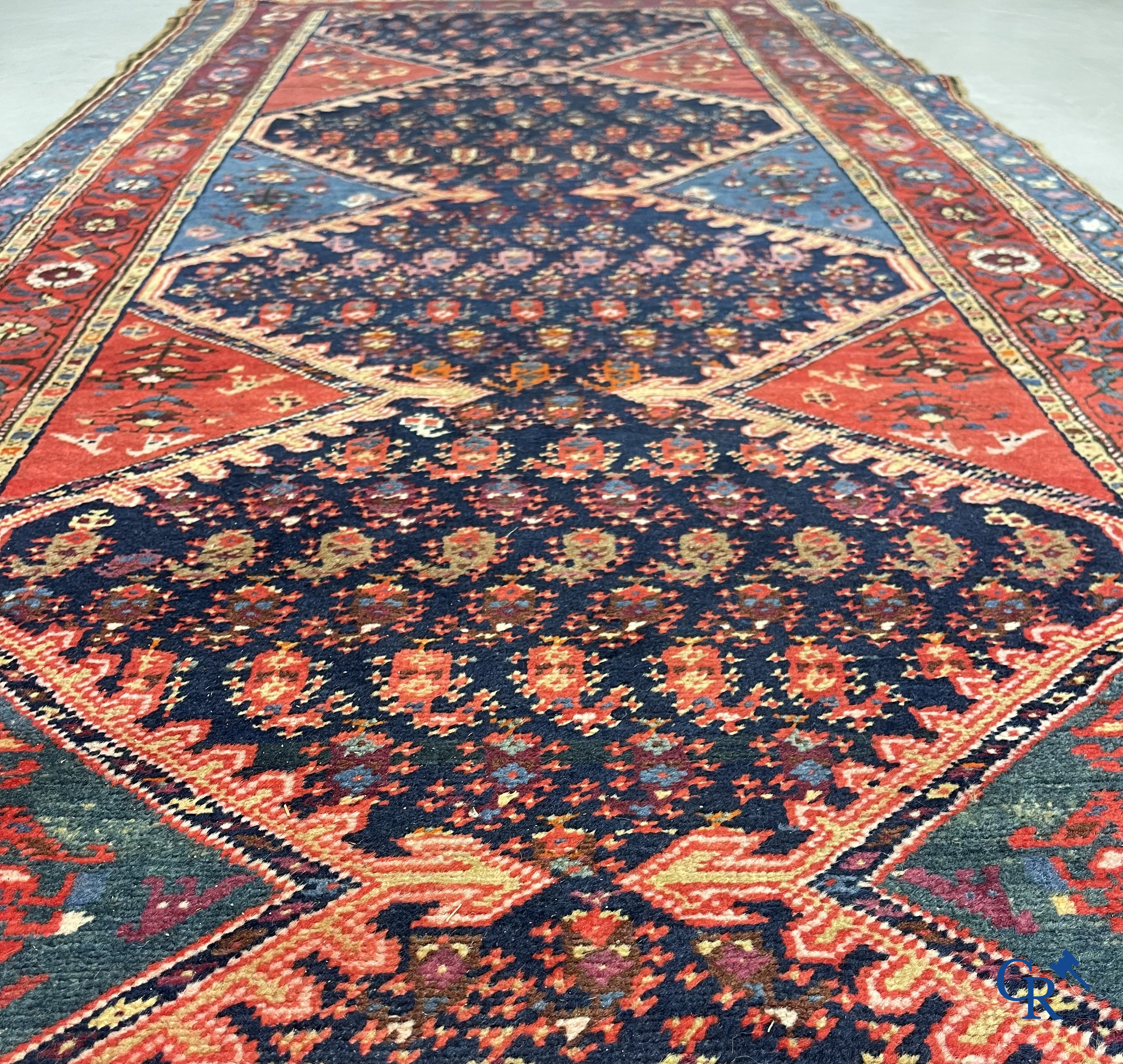 Oriental carpets. A large hand-knotted antique runner with geometric motifs. 19th century.