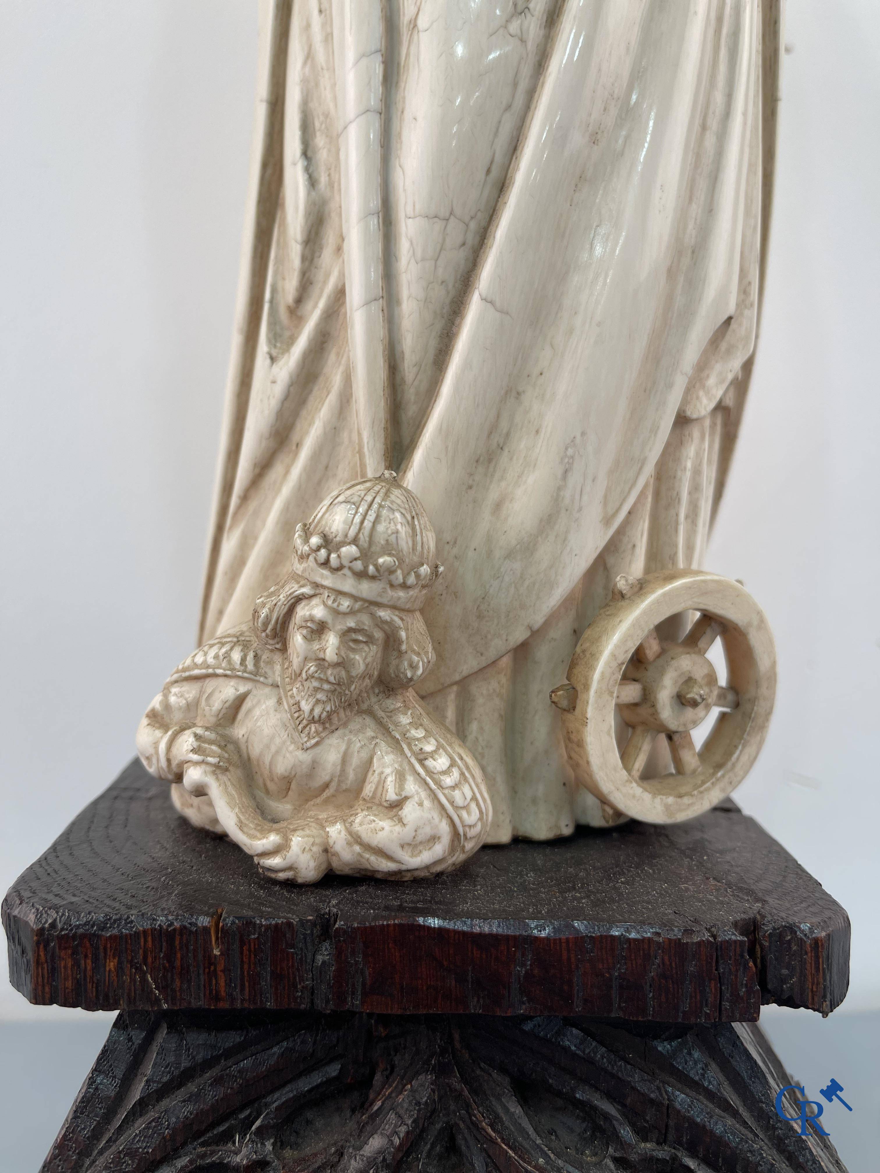 Représentation en ivoire de Sainte Catherine avec l'empereur Maxence sur un piédestal néo-gothique en bois. 