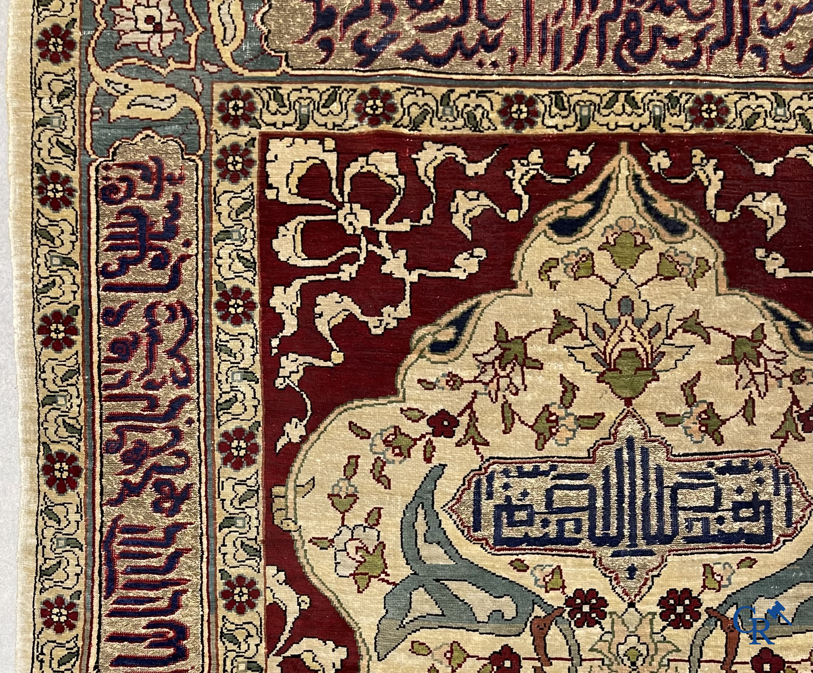 Oosterse tapijten. Een zijden gesigneerd tapijtje met inscripties en bewerkt met gouddraad.