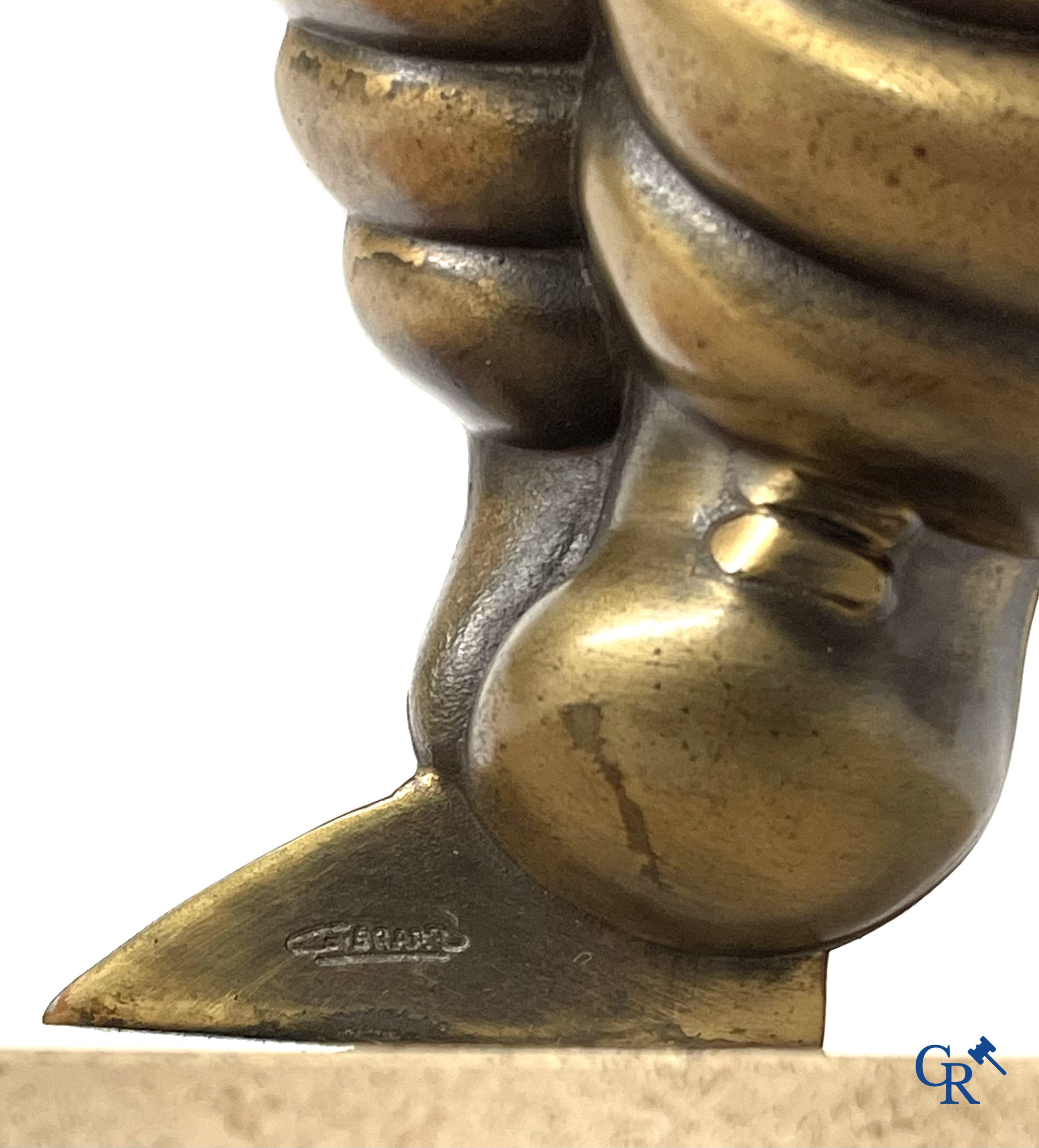 Michelin, Presentation of a running Bibendum in patinated bronze on a stone pedestal. Signed Gerard.