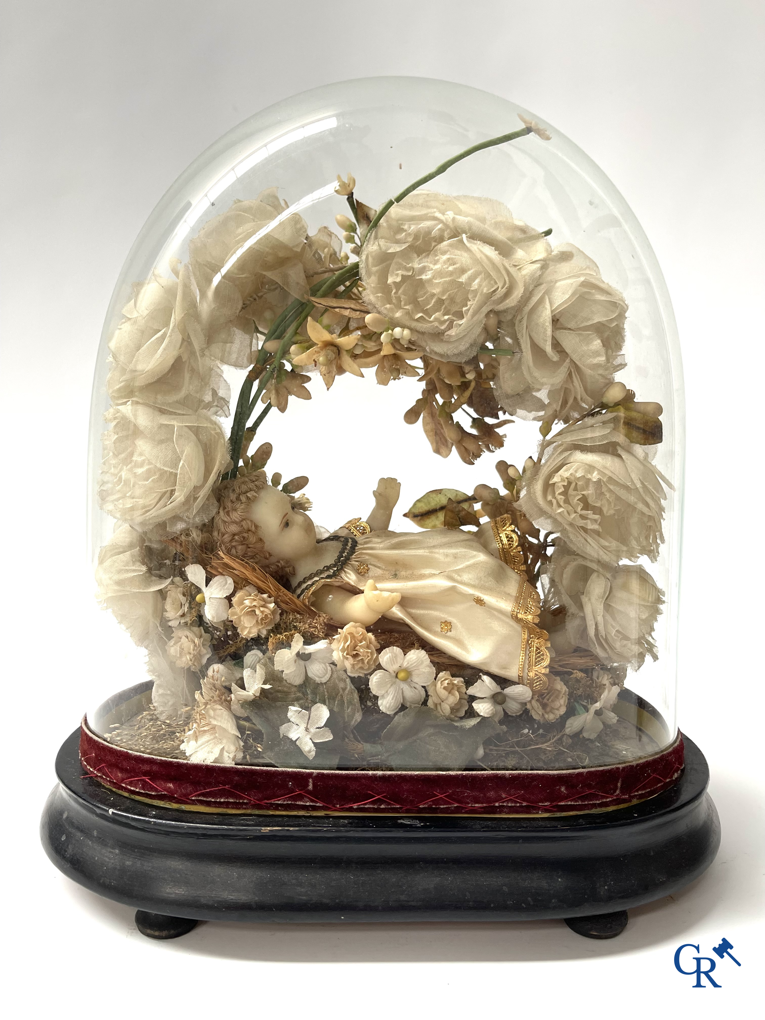 A globe in glass with a child in wax and a brass display case with bridal bouquet. Around 1900.