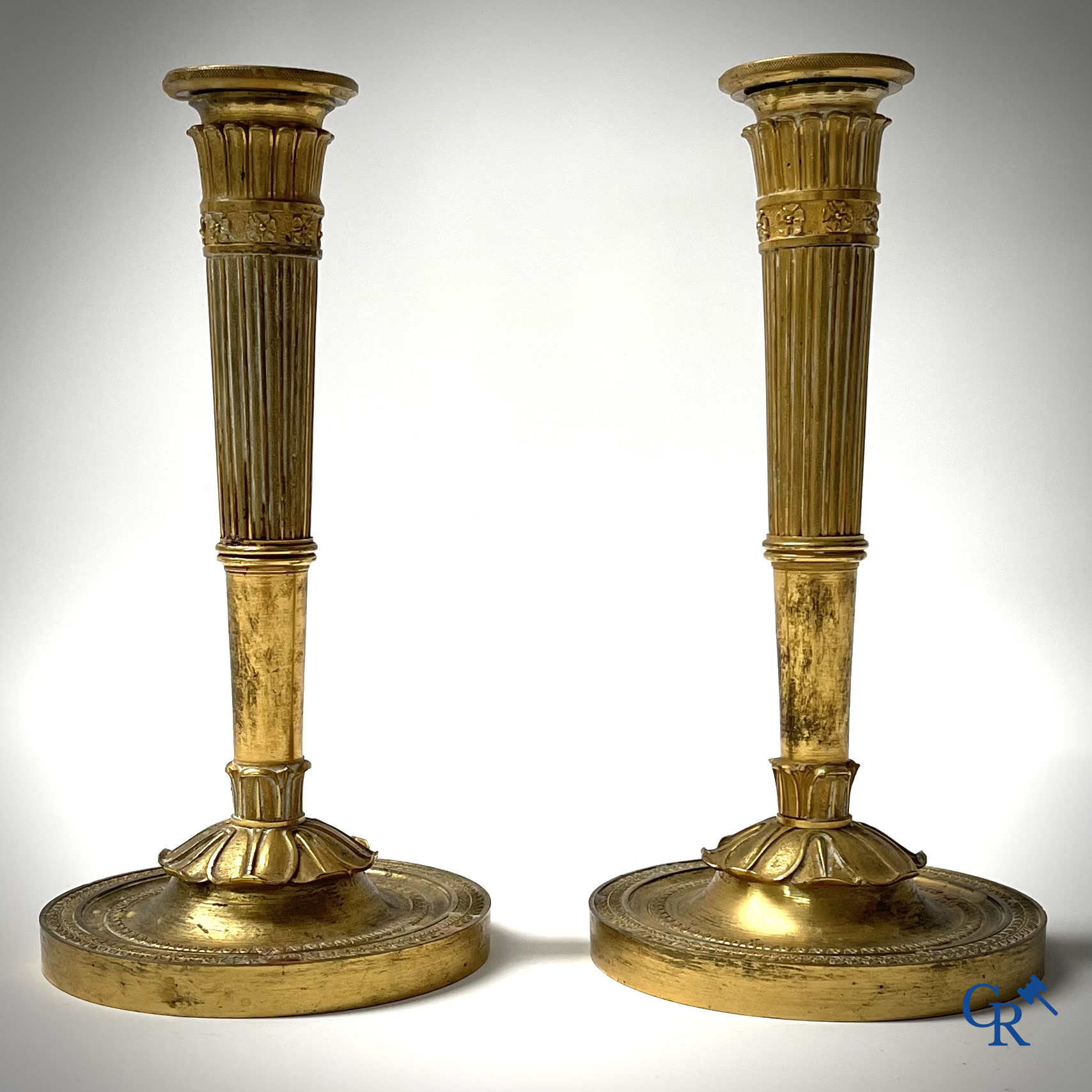 Empire era, a pair of finely chiseled and gilded bronze candlesticks. France, early 19th century.