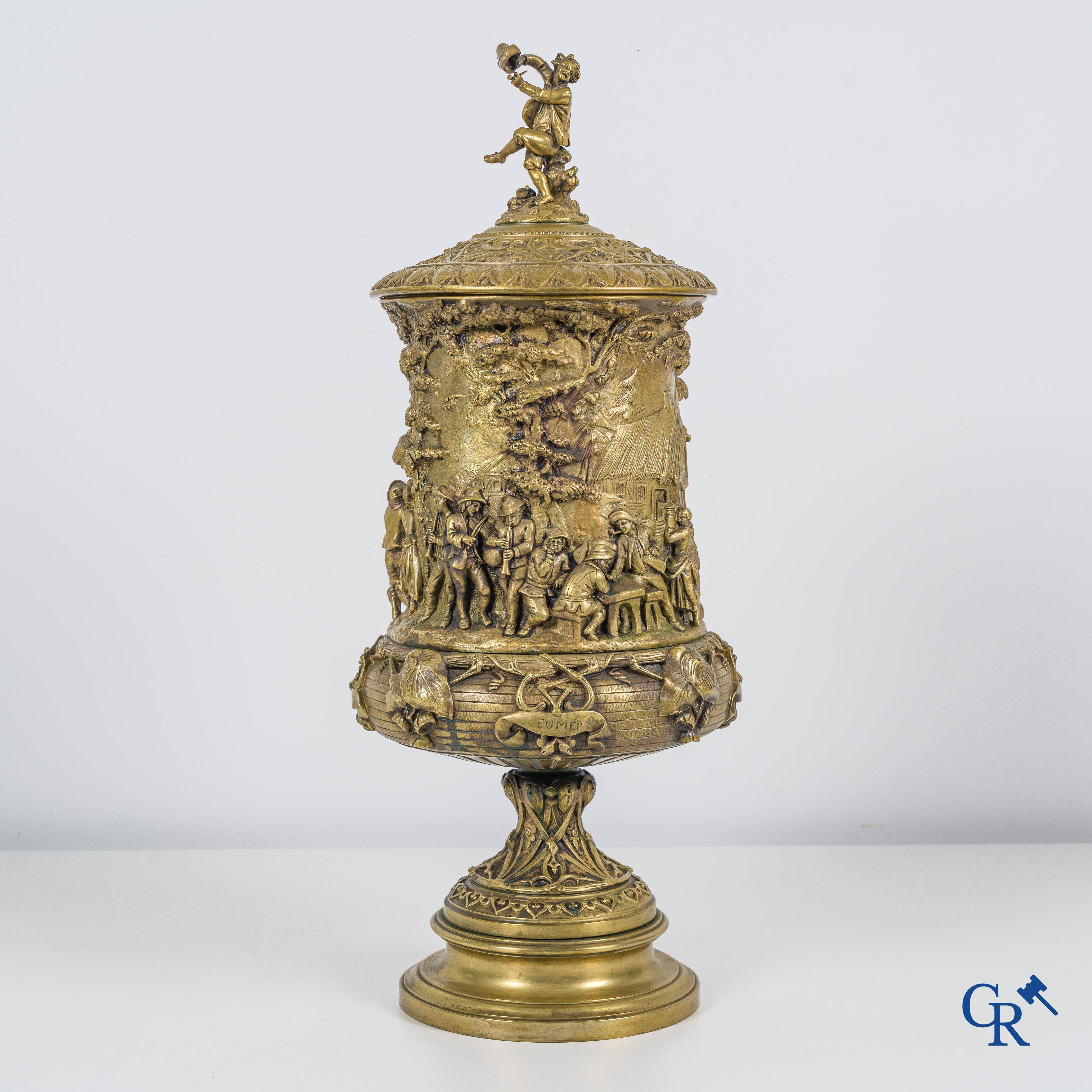 Un imposant pot à tabac en bronze finement travaillée avec les inscriptions "aimer, danser, fumer, boire".<br />
19ème siècle.