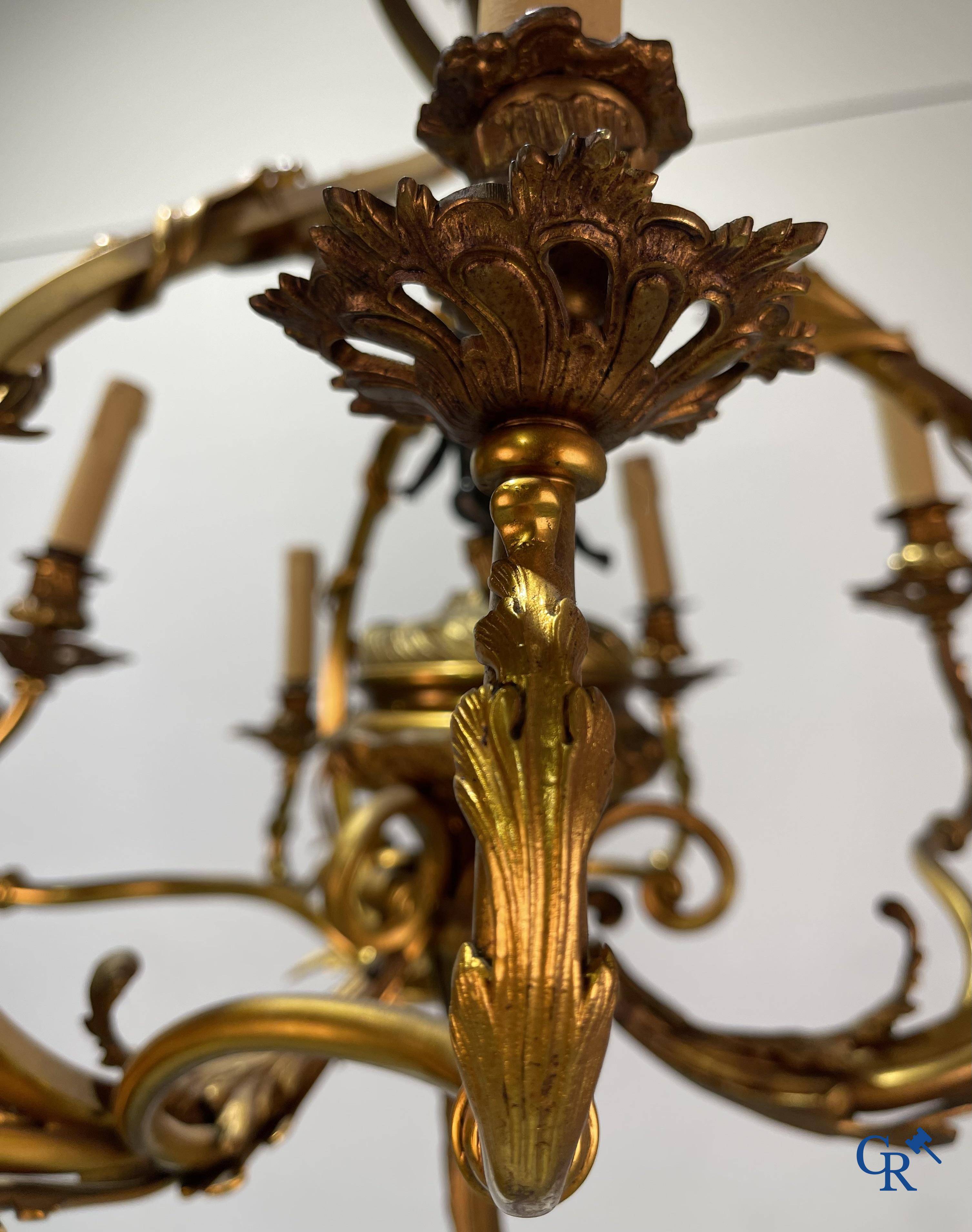 A bronze chandelier with putti and 9 light points in LXV style. Circa 1920.