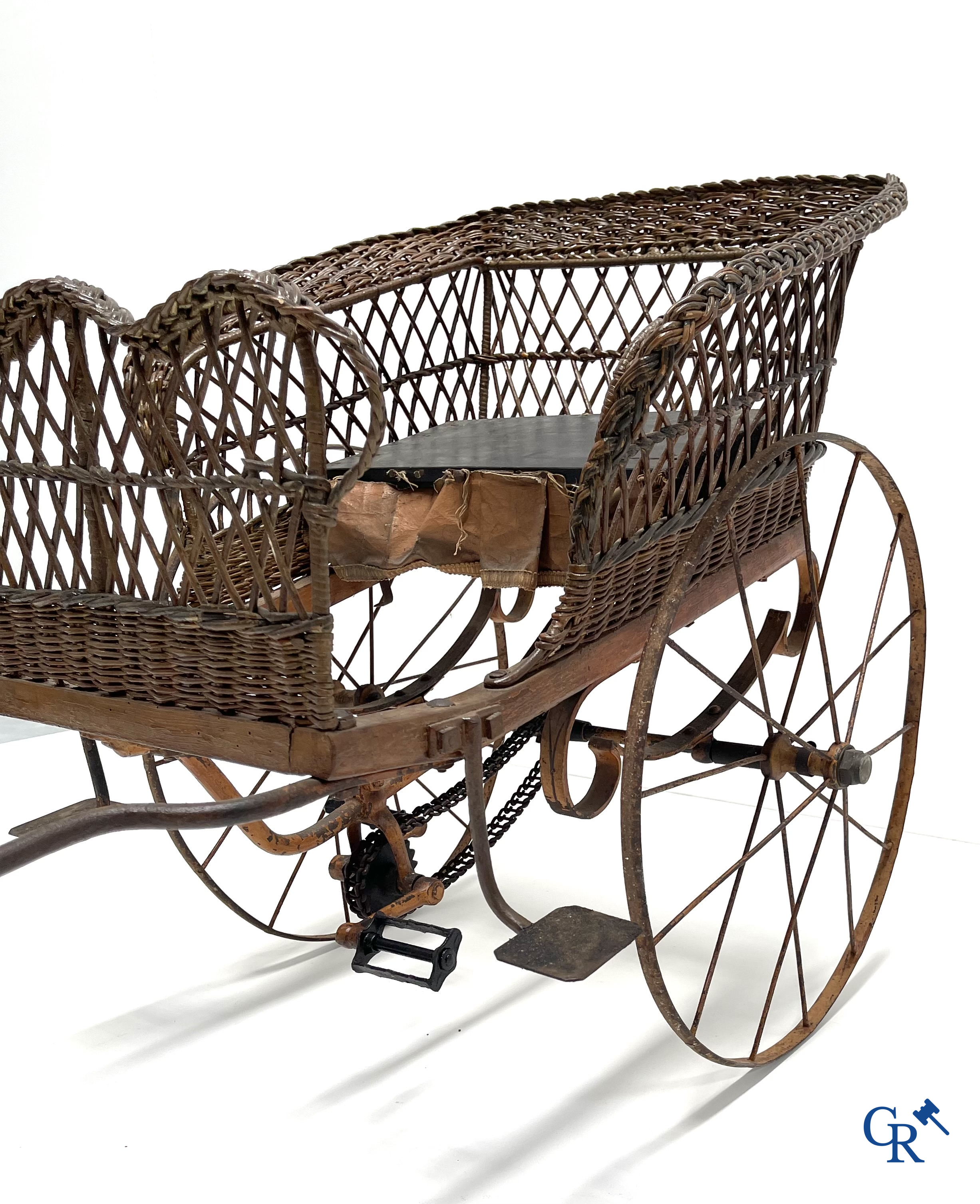 Zeldzame mechanische kinderkar in gevlochten riet en beschilderd metaal ontworpen door Peugeot. Circa 1900.