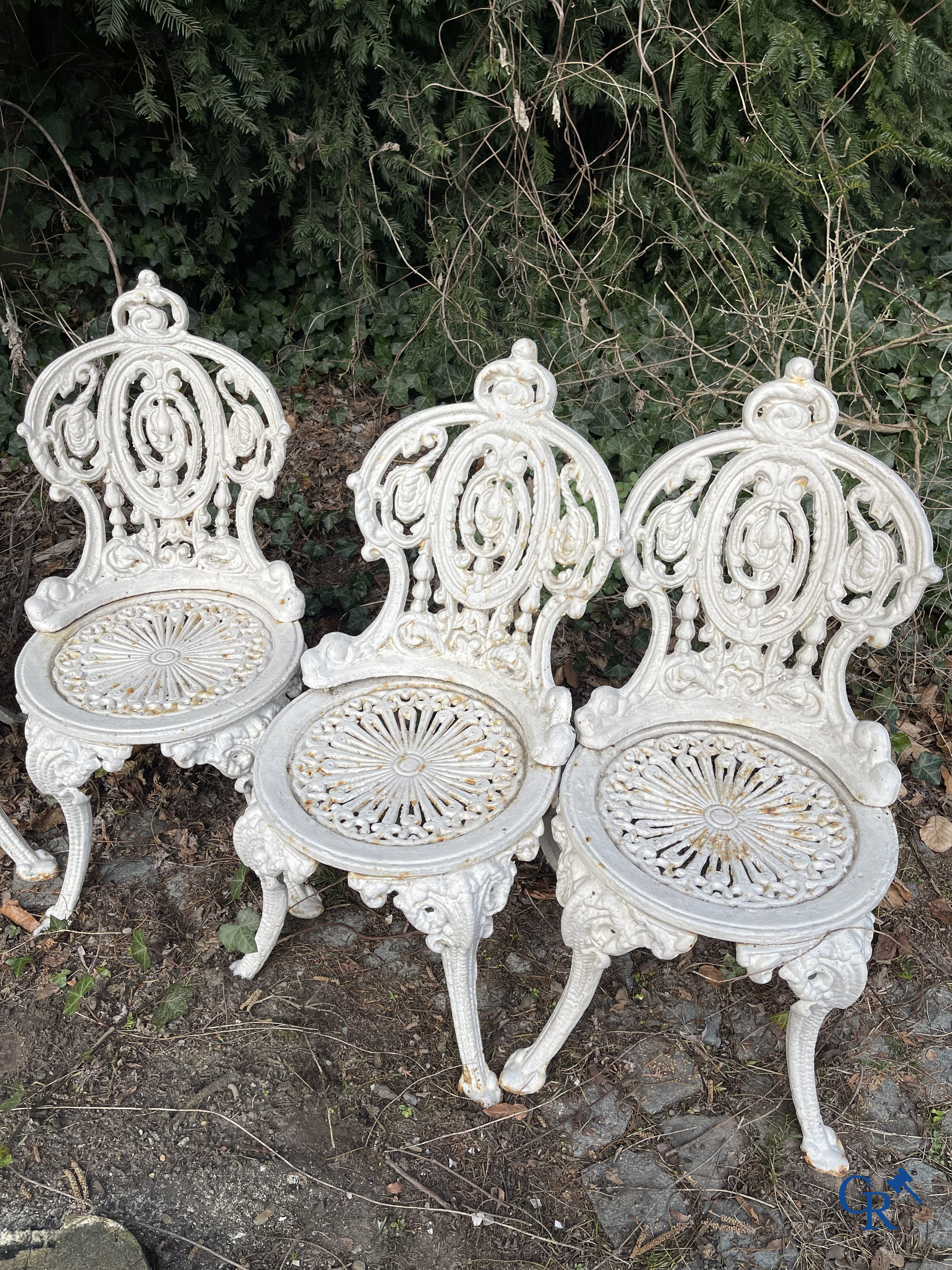 Een reeks van 6 tuinstoelen en 3 geuridons in gietijzer, een metalen tuinbankje bijgevoegd.