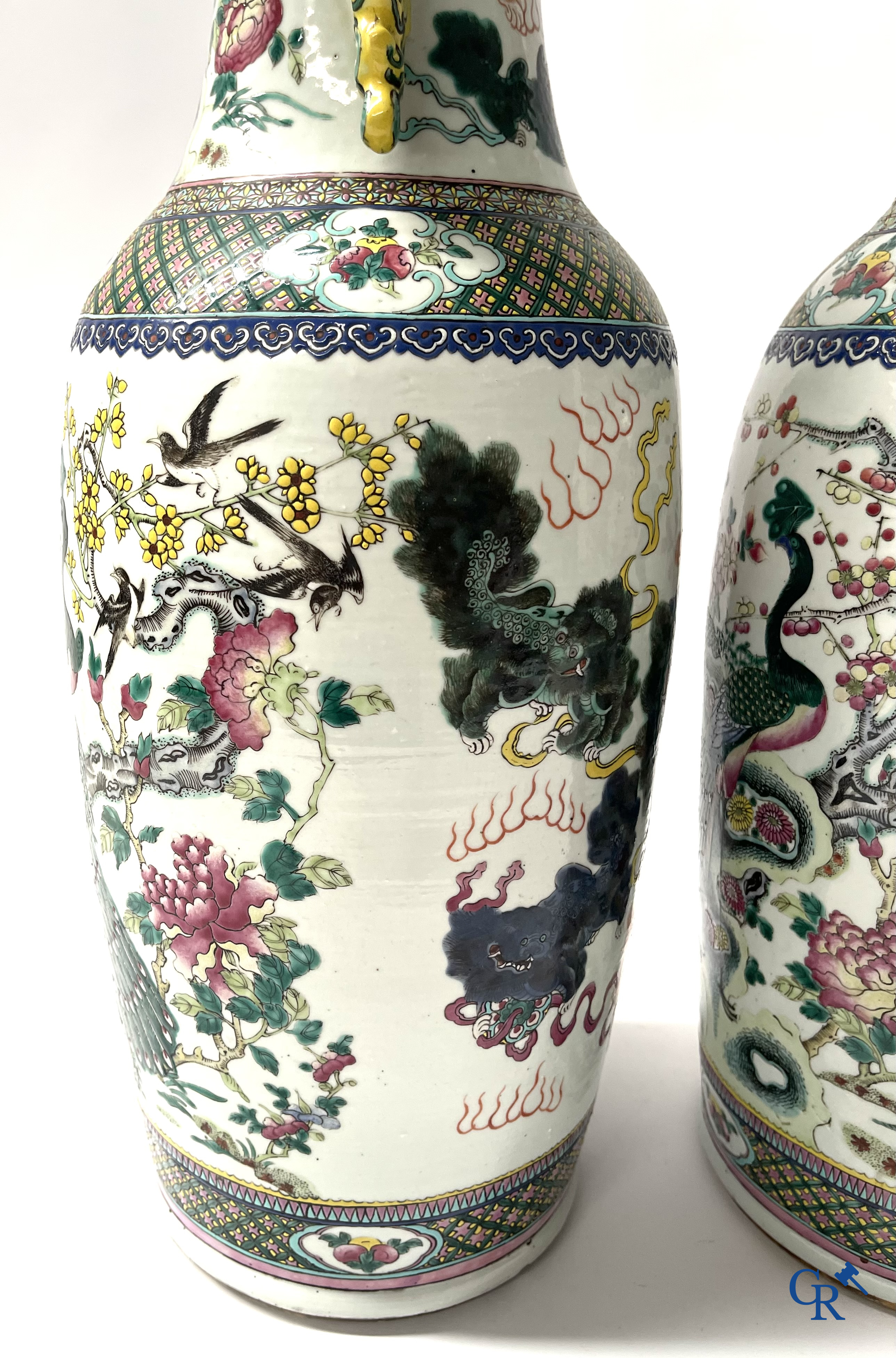 Asian Art, A pair of Chinese famille rose vases with peacocks and Fo dogs. 19th century.