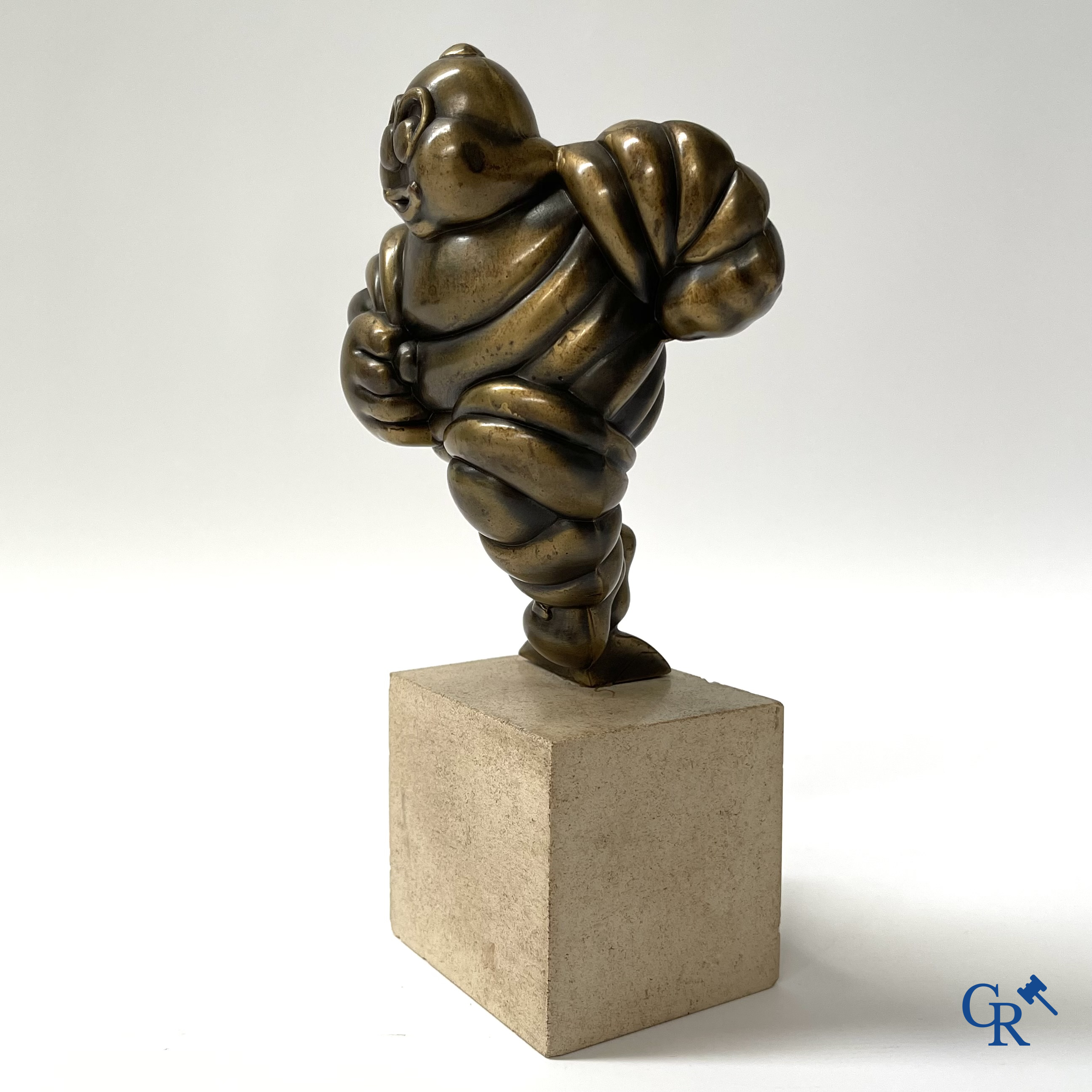 Michelin, Presentation of a running Bibendum in patinated bronze on a stone pedestal. Signed Gerard.