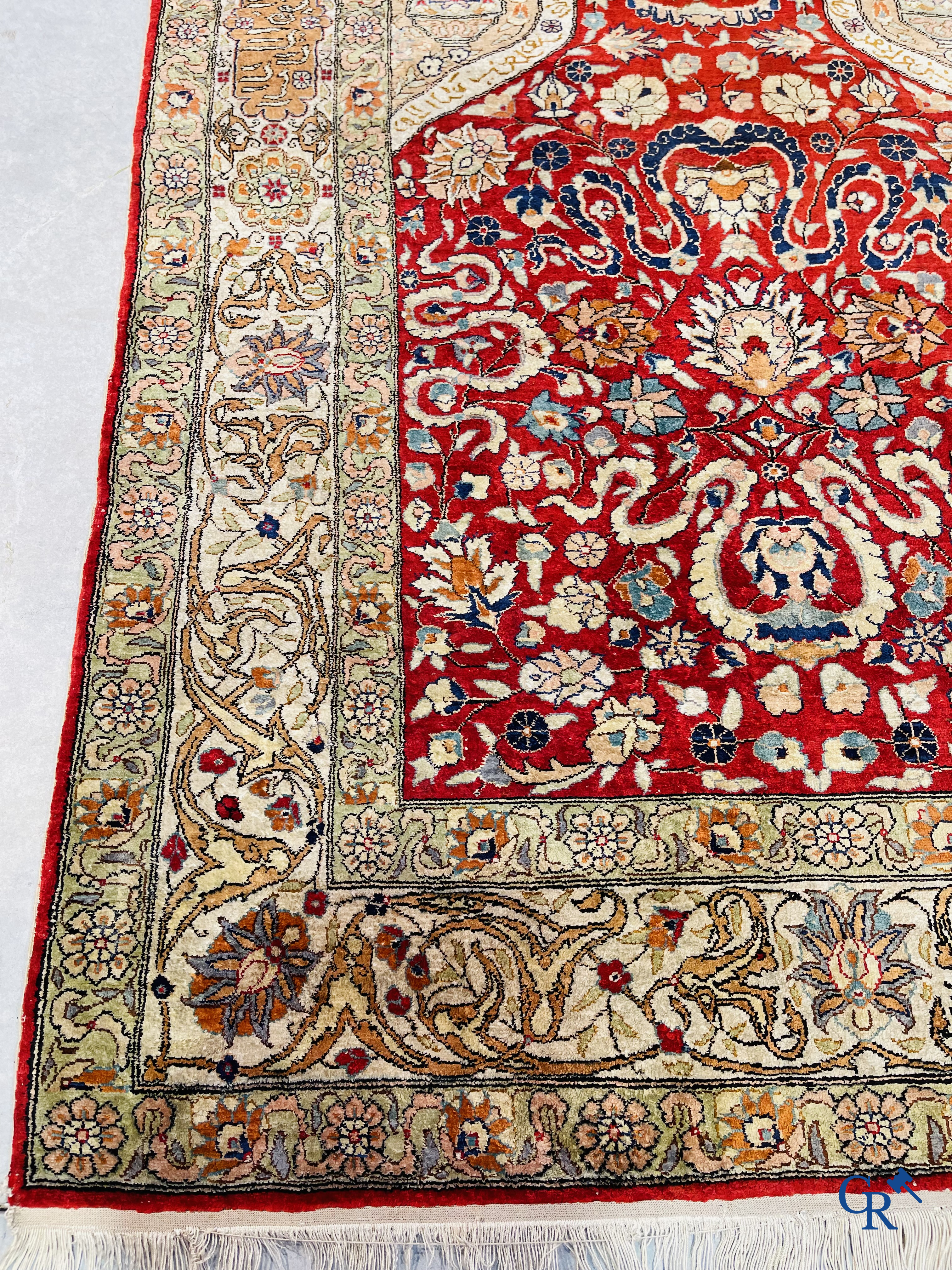 Oriental carpets: Hereke, a finely knotted silk carpet with inscriptions and birds in a floral decor.
