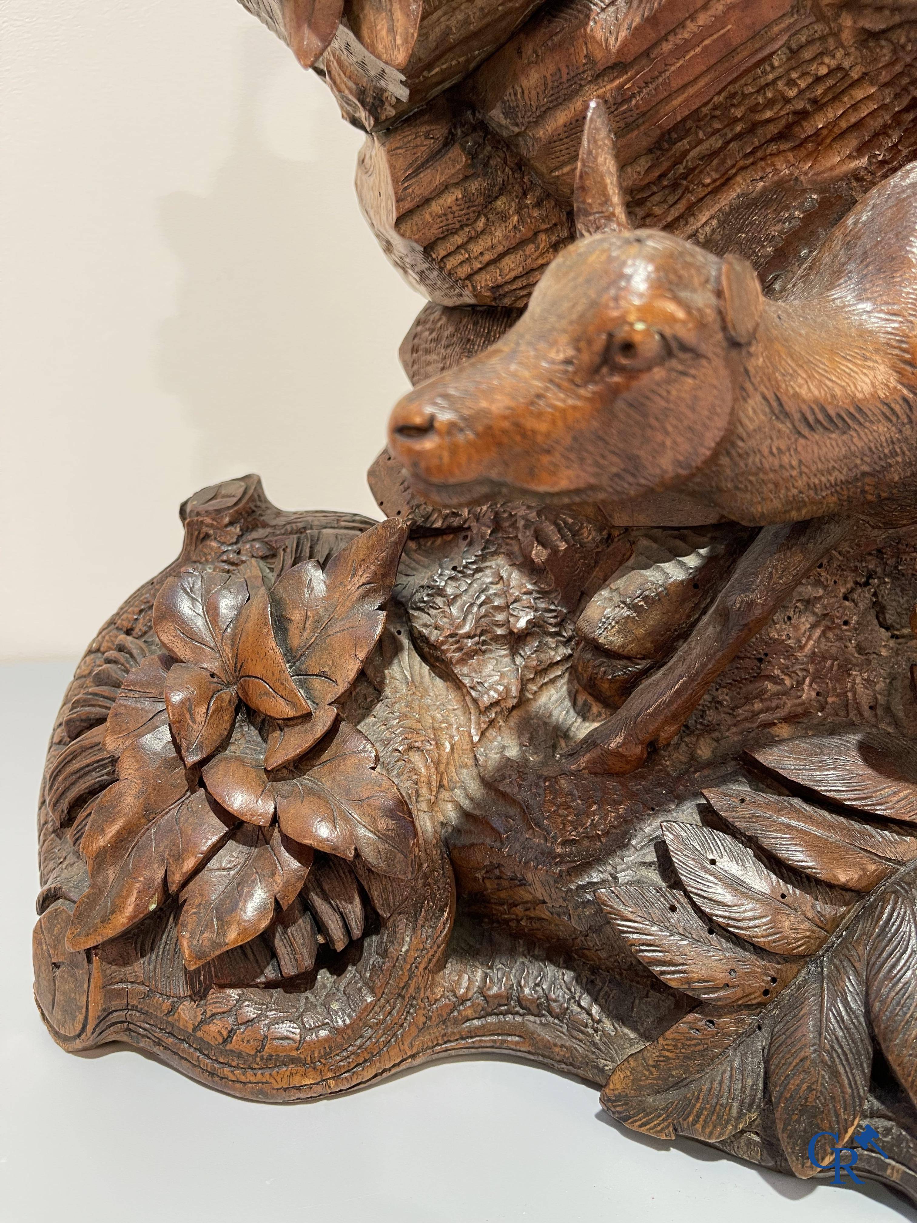 A wood sculpted Black Forest clock with deer in their flora. Germany, late 19th century.