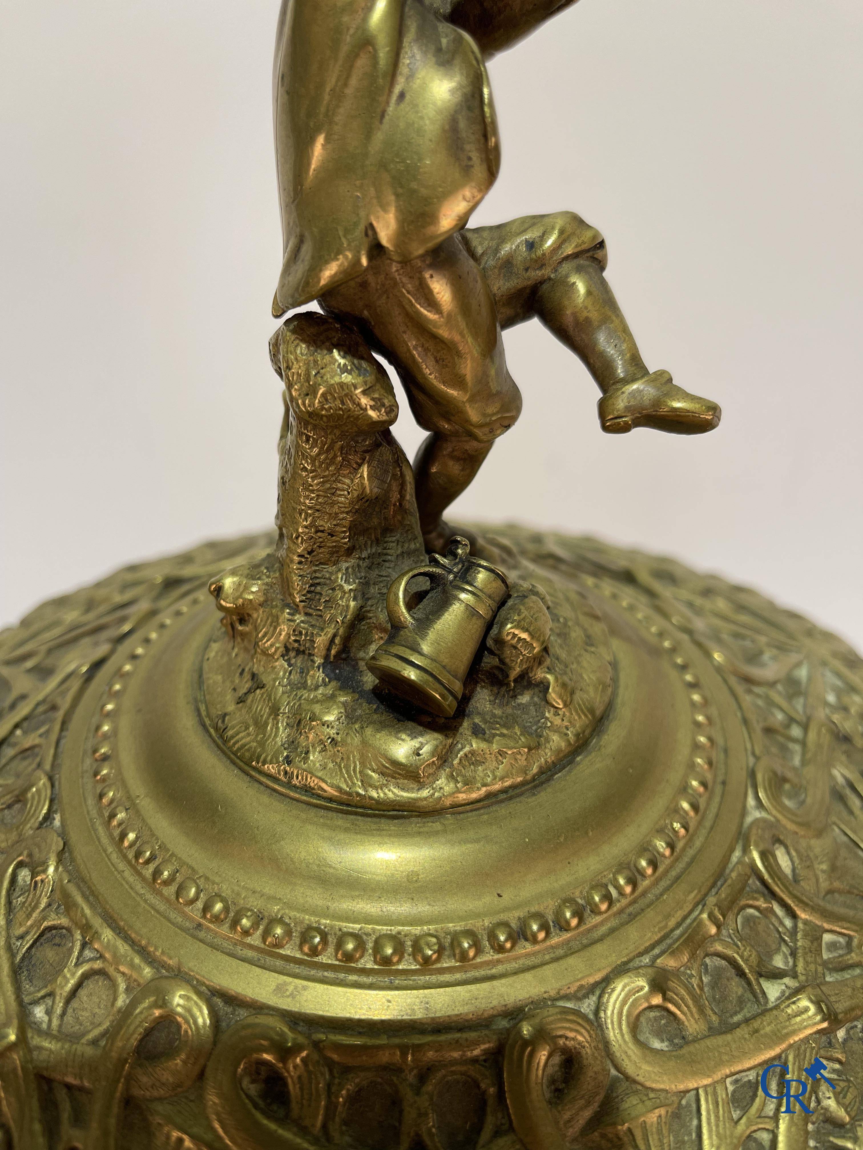 Un imposant pot à tabac en bronze finement travaillée avec les inscriptions "aimer, danser, fumer, boire".<br />
19ème siècle.