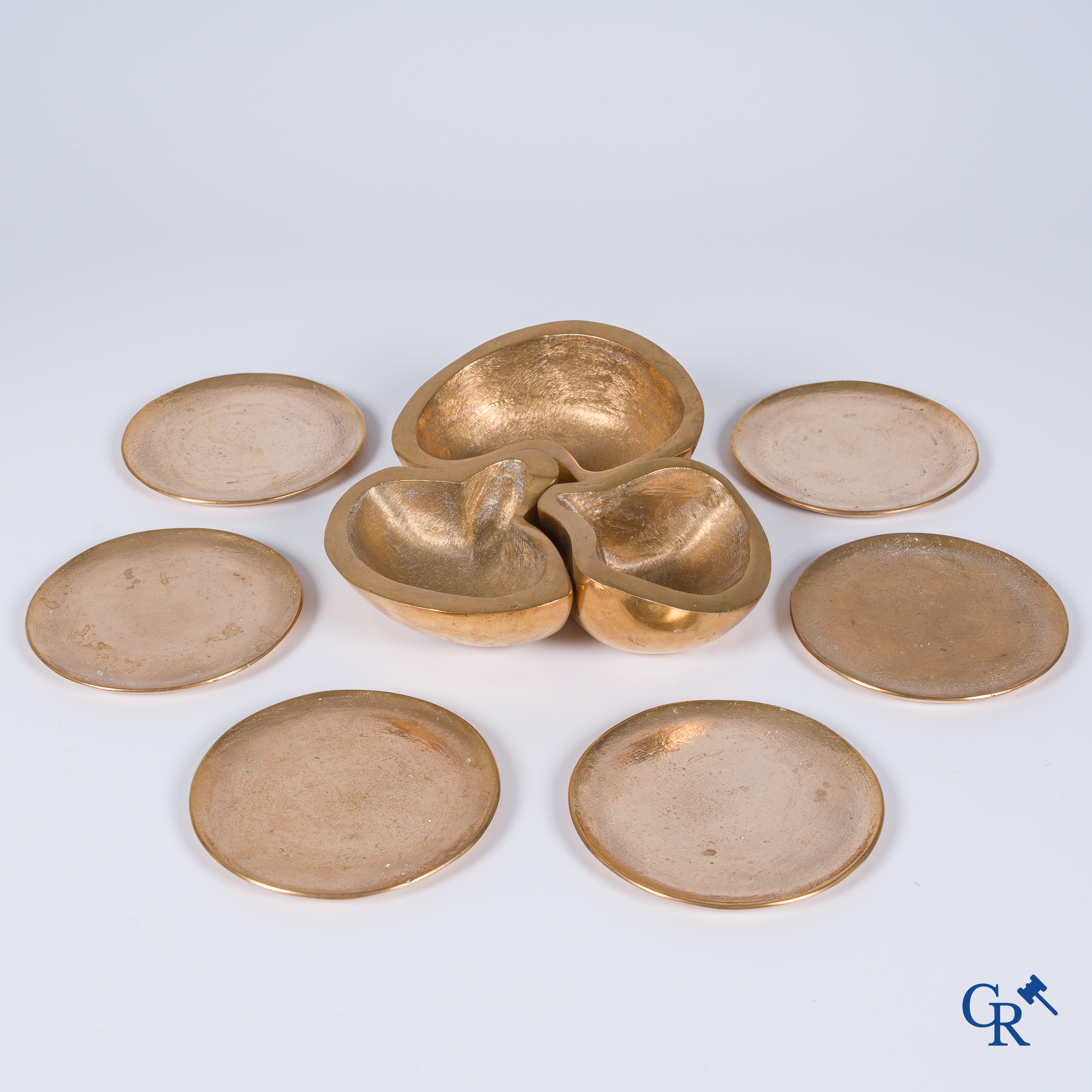 Margrit Van Nuffel (1943) A 3-piece table set and a set of 6 glass coasters in polished massive bronze. Circa 1970.