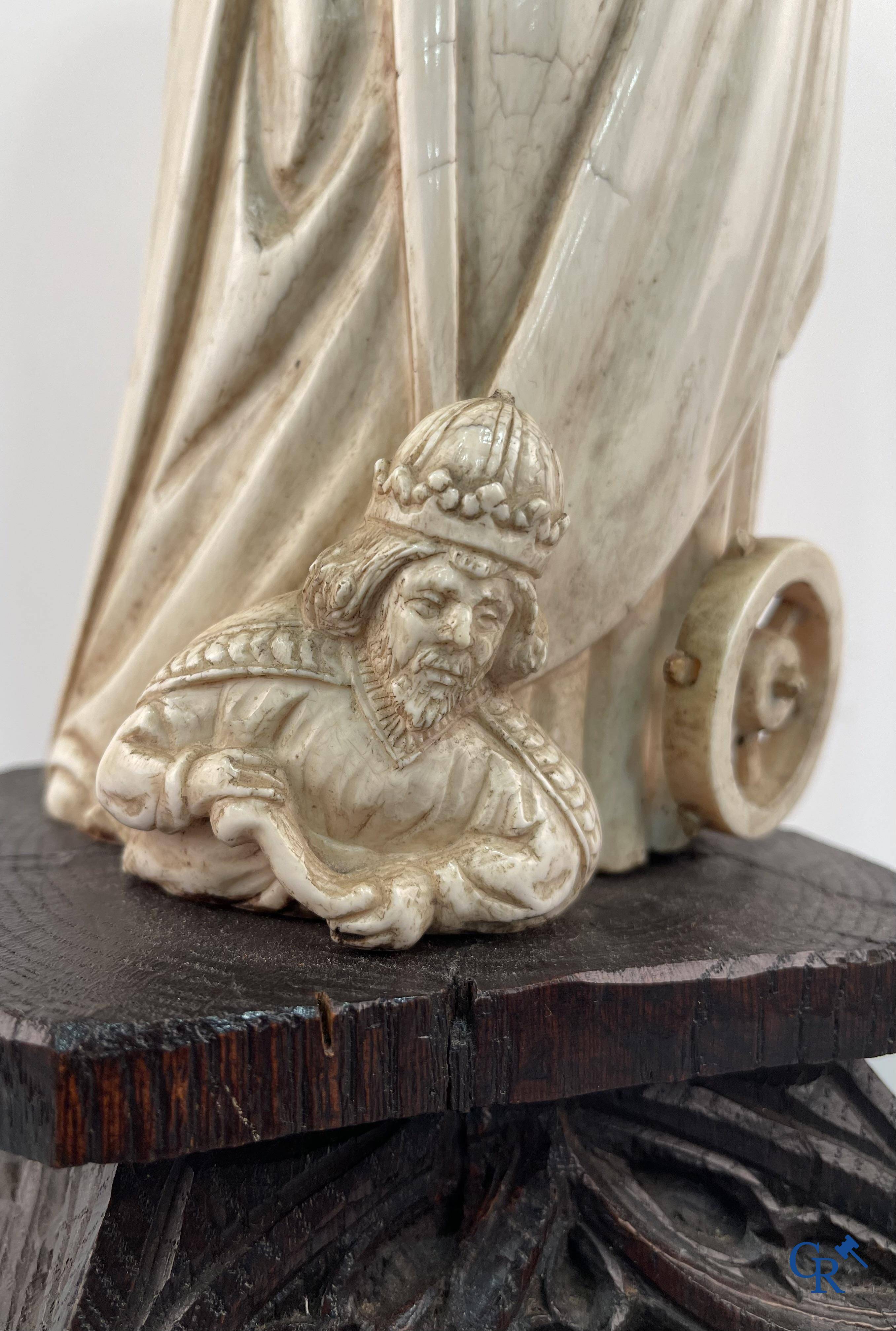 Représentation en ivoire de Sainte Catherine avec l'empereur Maxence sur un piédestal néo-gothique en bois. 
