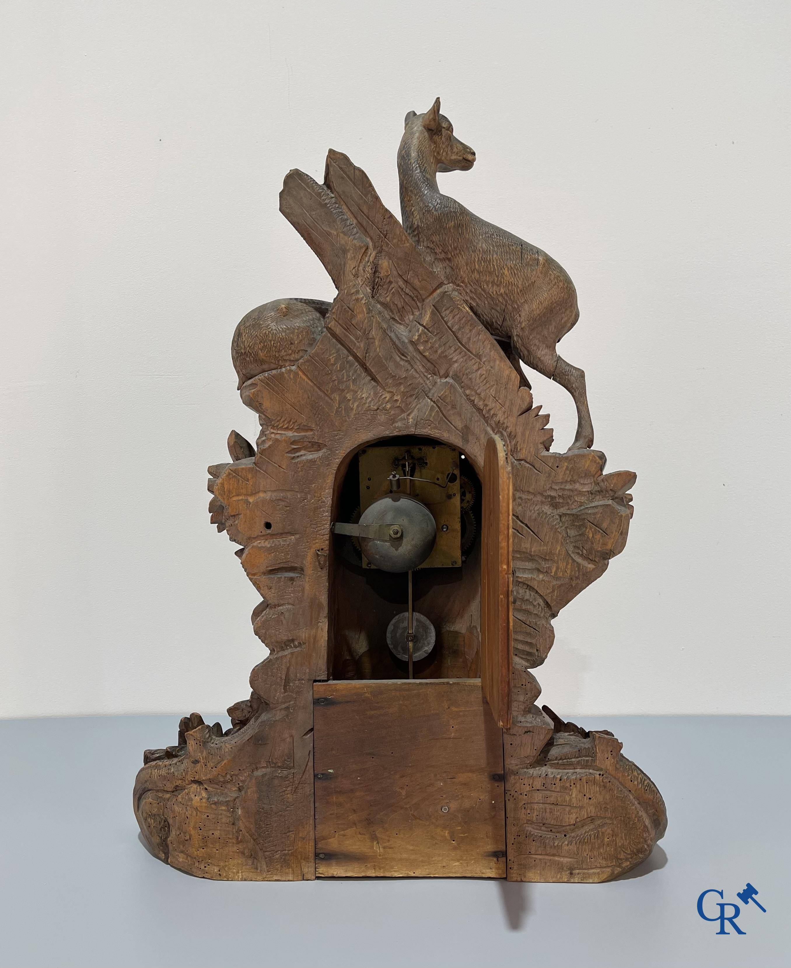 A wood sculpted Black Forest clock with deer in their flora. Germany, late 19th century.