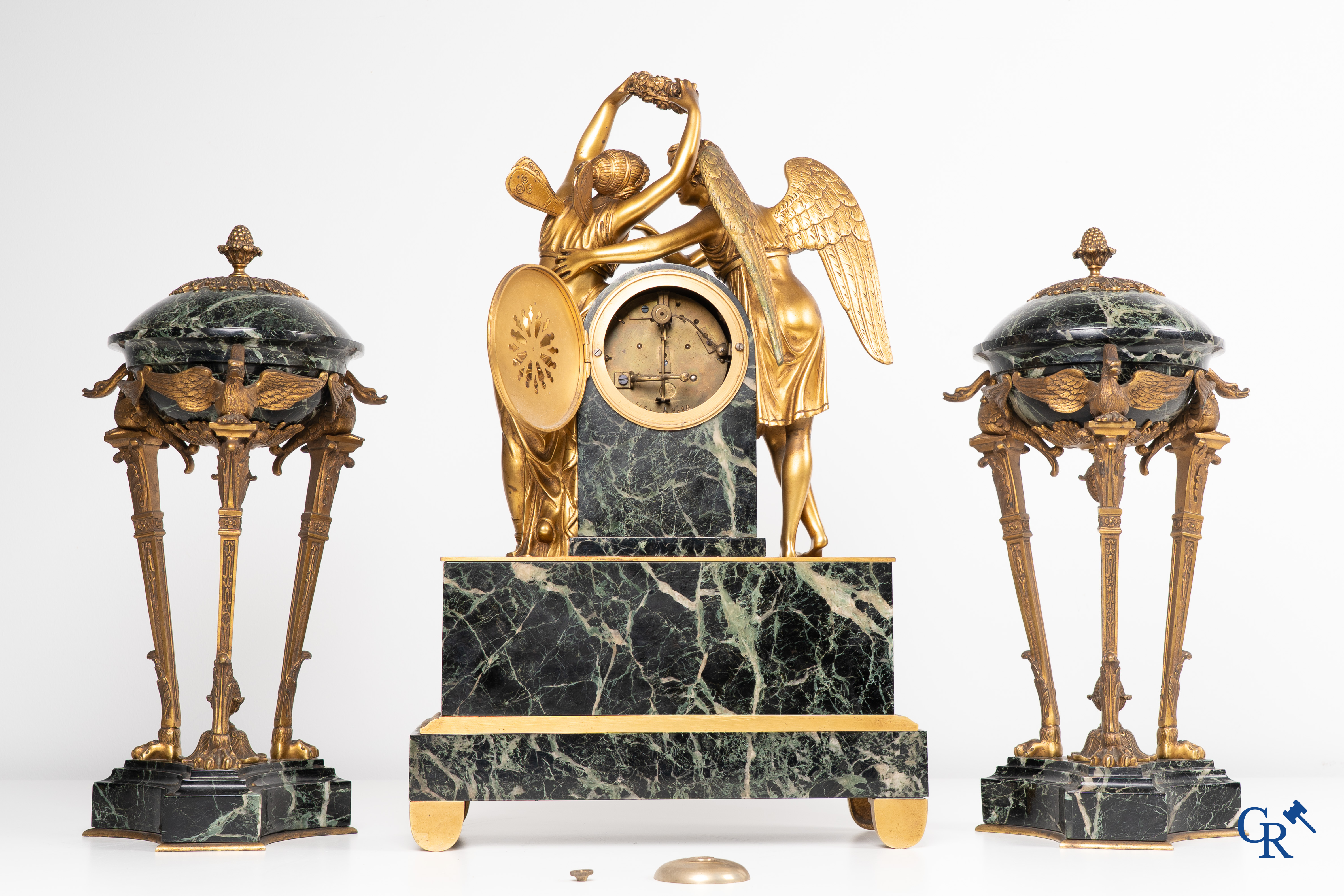 Een 3-delige schouwgarnituur in groen geaderde marmer en vergulde brons. Empire stijl. Circa 1900.