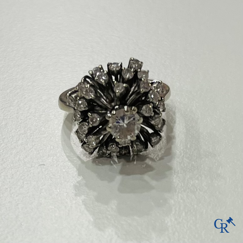 Jewellery, a ring in white gold 750°/00 set with a central brilliant and several small diamonds.