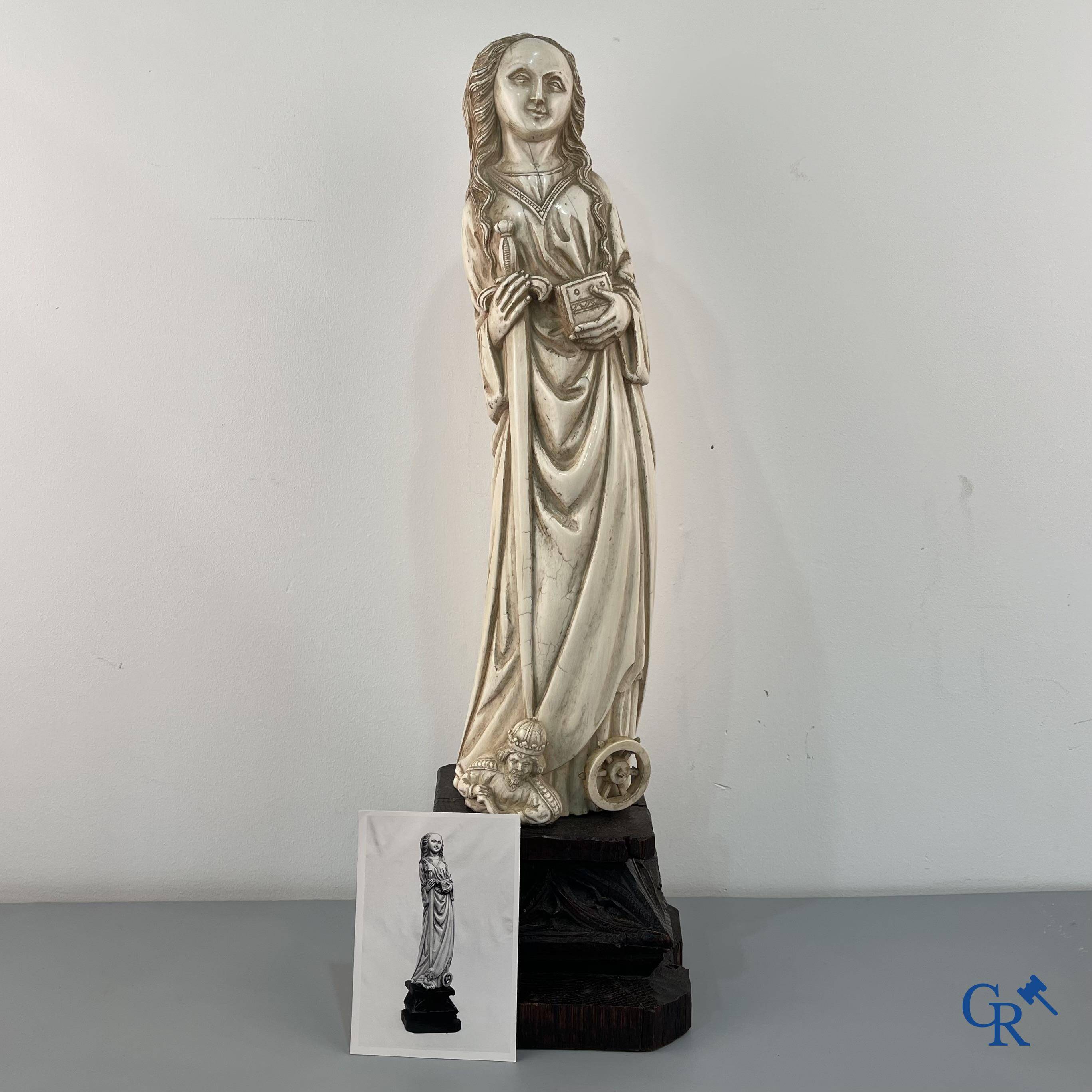 Représentation en ivoire de Sainte Catherine avec l'empereur Maxence sur un piédestal néo-gothique en bois. 