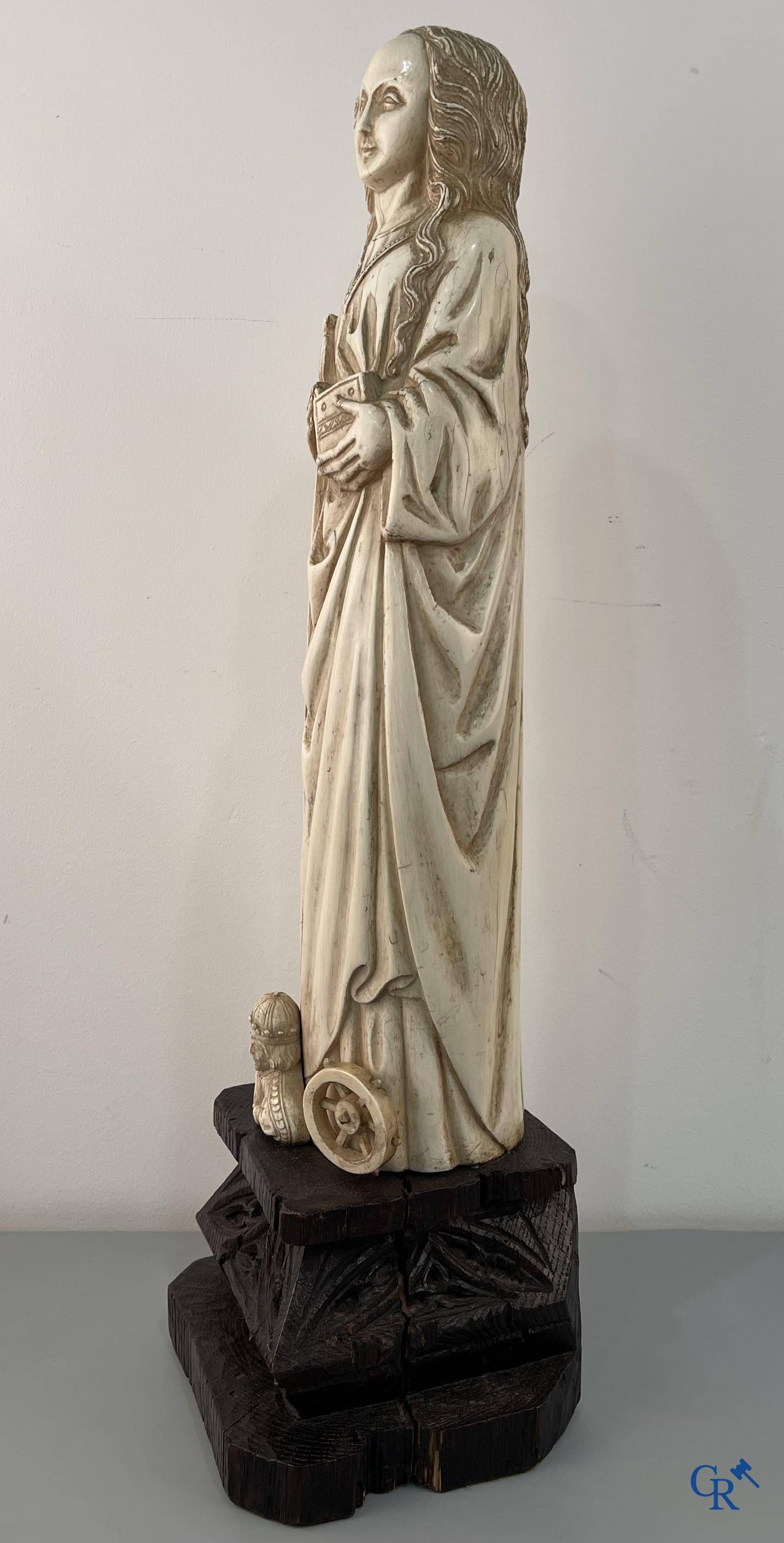Représentation en ivoire de Sainte Catherine avec l'empereur Maxence sur un piédestal néo-gothique en bois. 