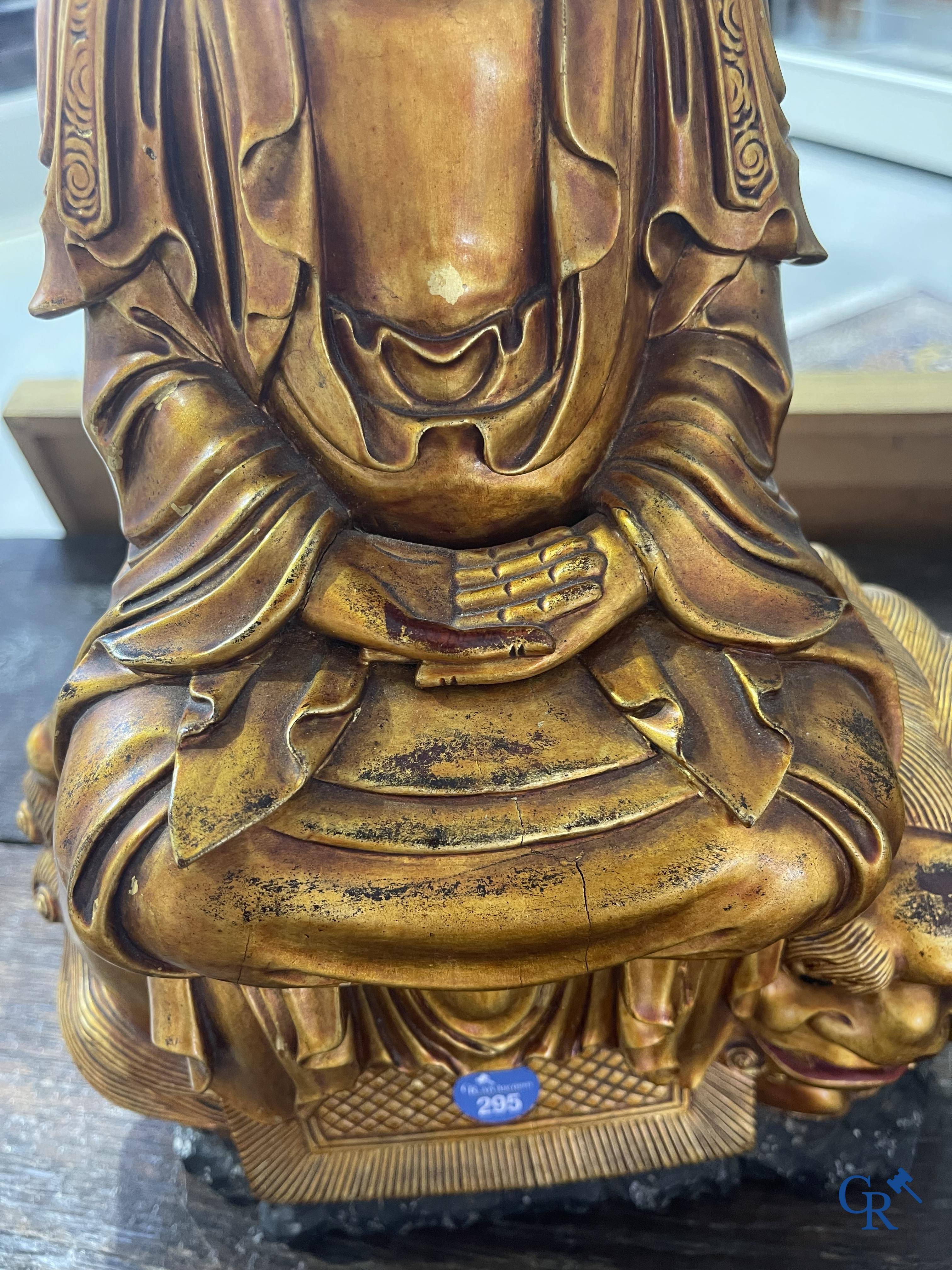 Asian Art: A Chinese sculpture of Vaishravana on a Buddhist lion in lacquered and gilded wood. 19th century.