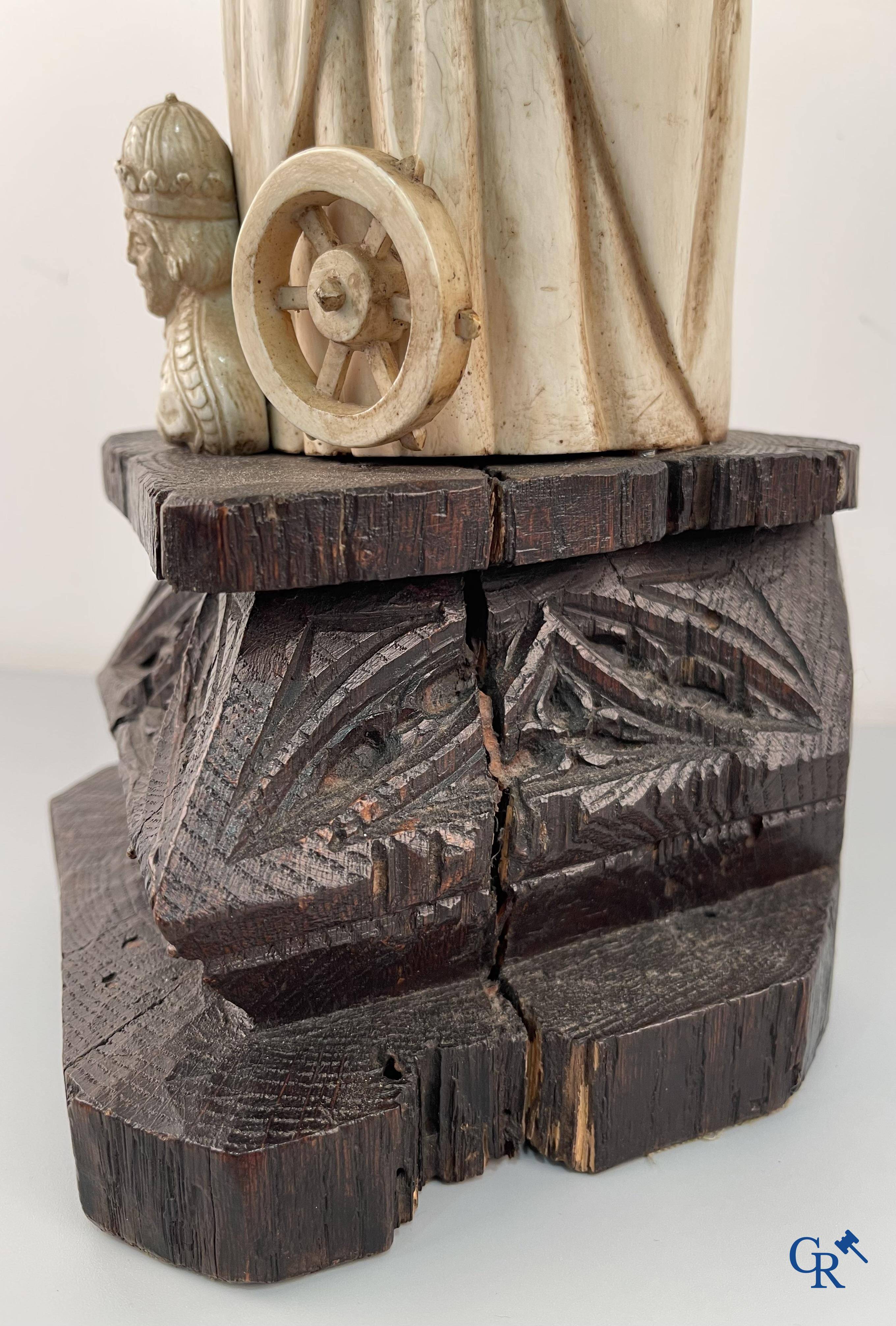 Représentation en ivoire de Sainte Catherine avec l'empereur Maxence sur un piédestal néo-gothique en bois. 