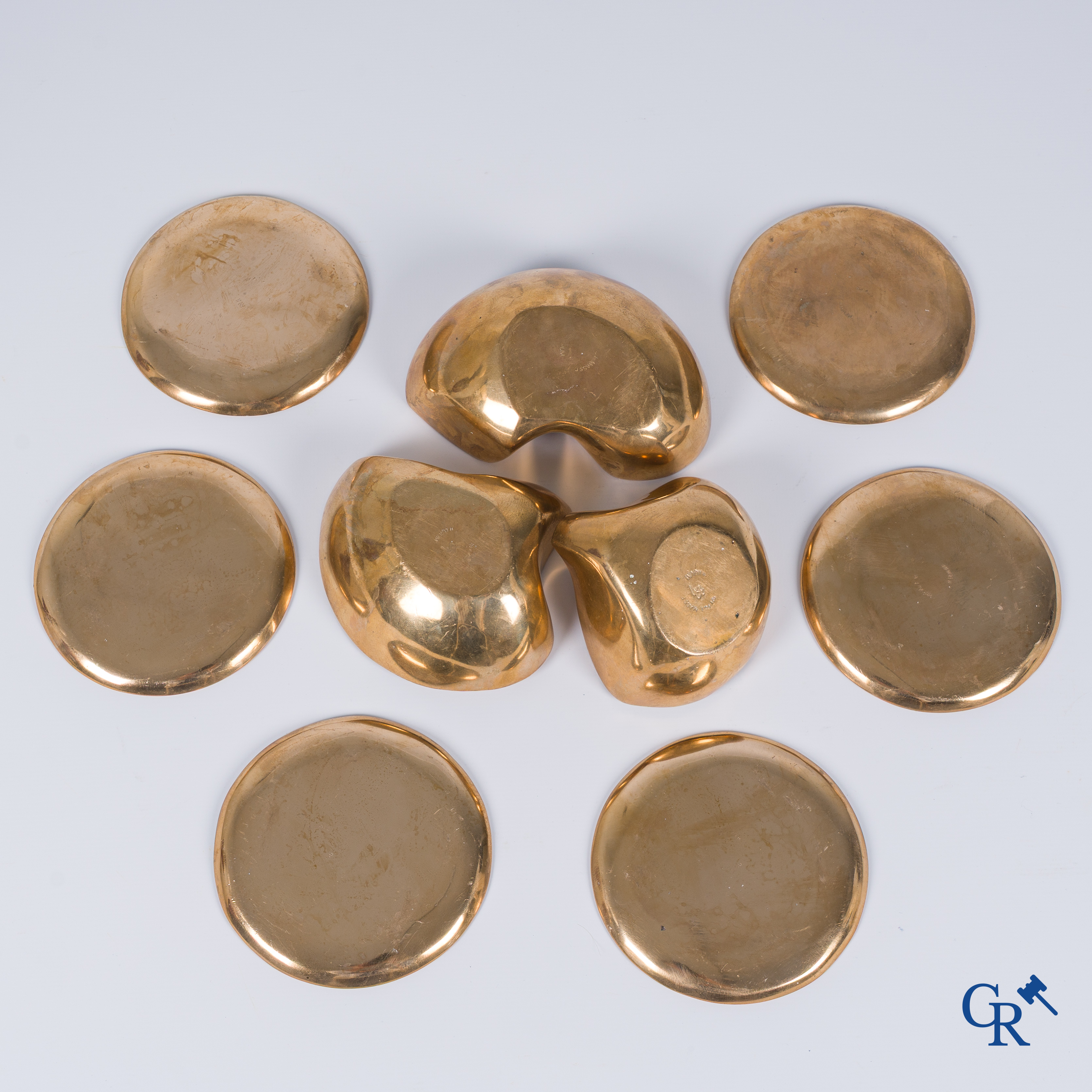 Margrit Van Nuffel (1943) A 3-piece table set and a set of 6 glass coasters in polished massive bronze. Circa 1970.