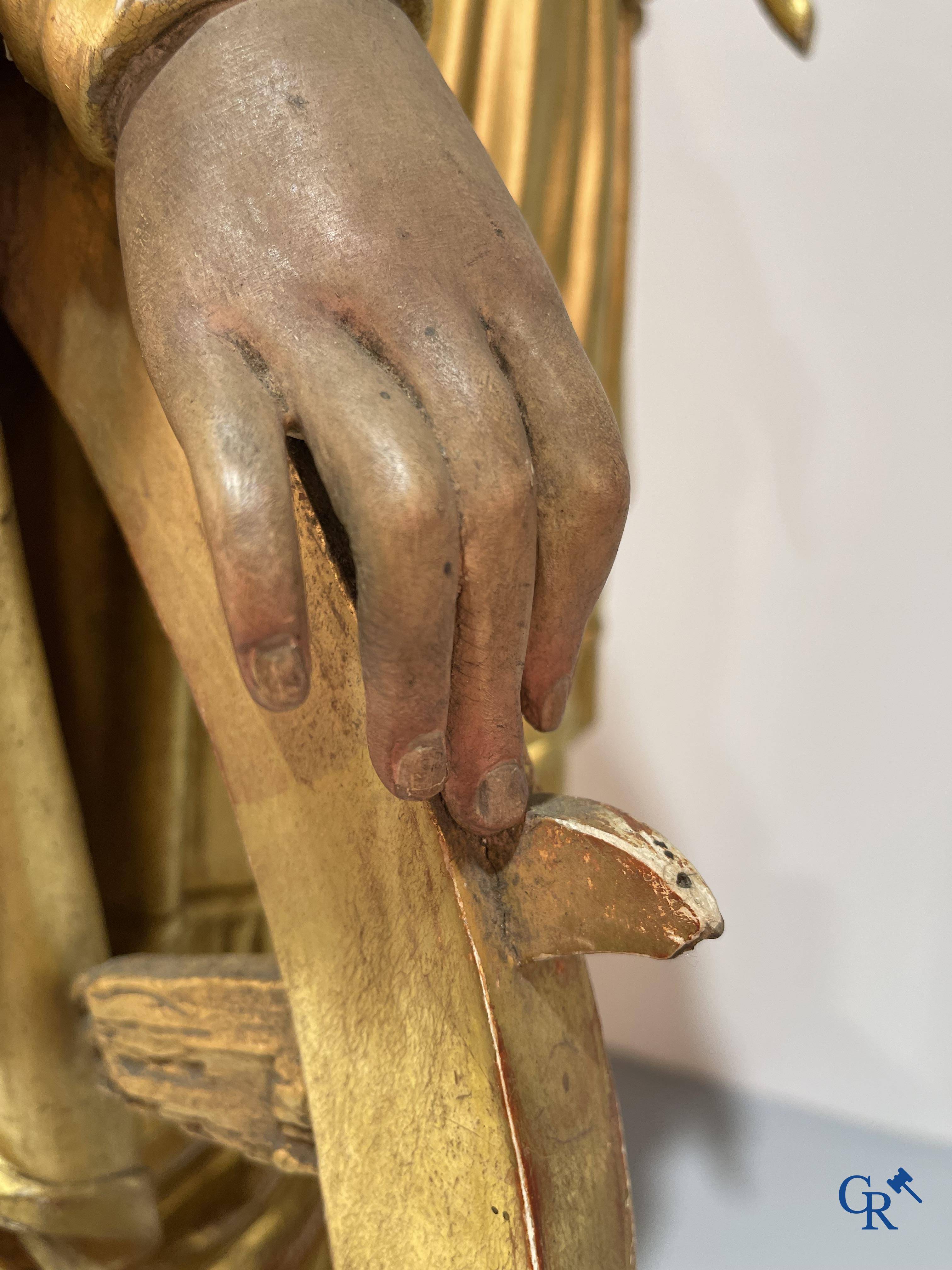 A large gilded and polychrome wooden statue of Saint Catherine of Alexandria.