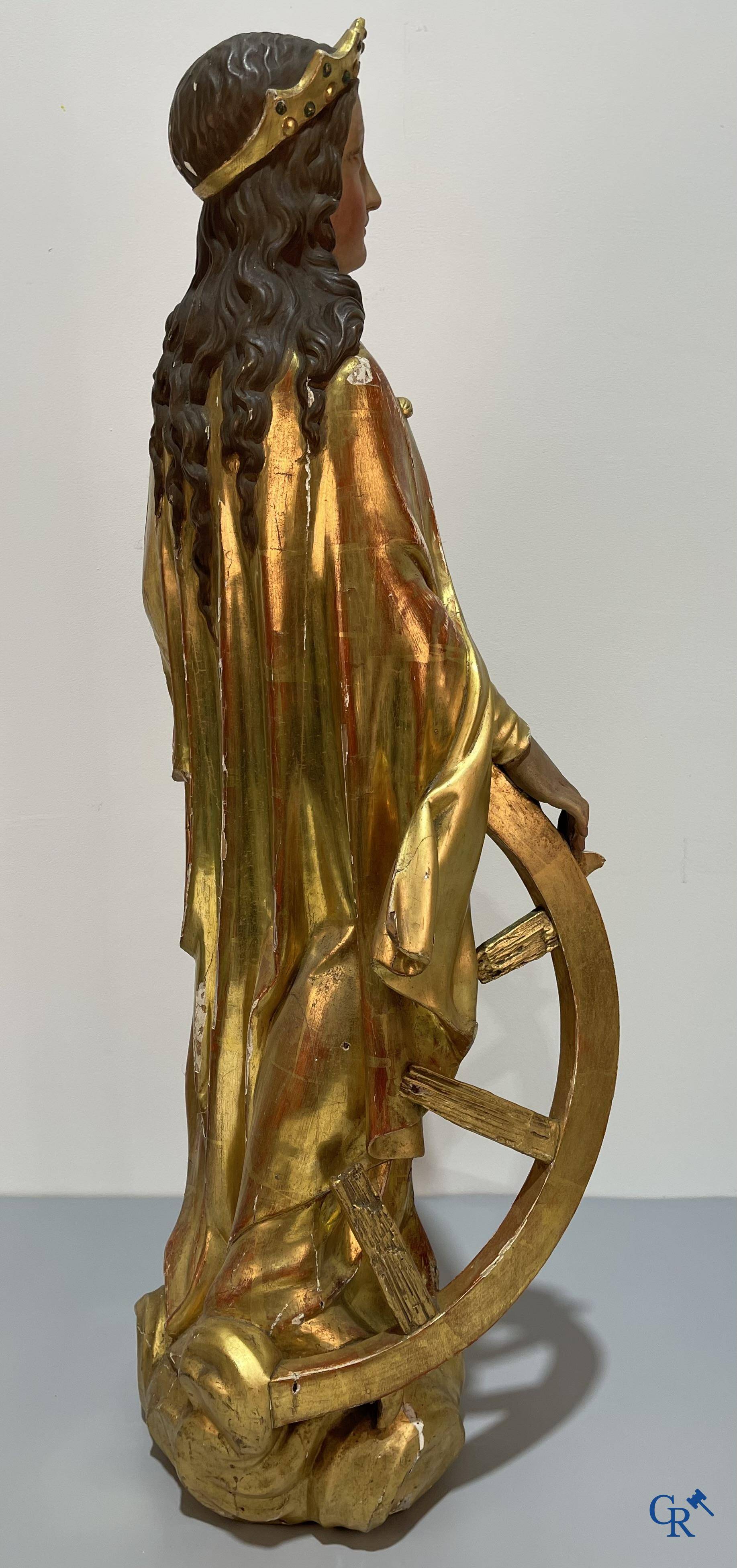 A large gilded and polychrome wooden statue of Saint Catherine of Alexandria.