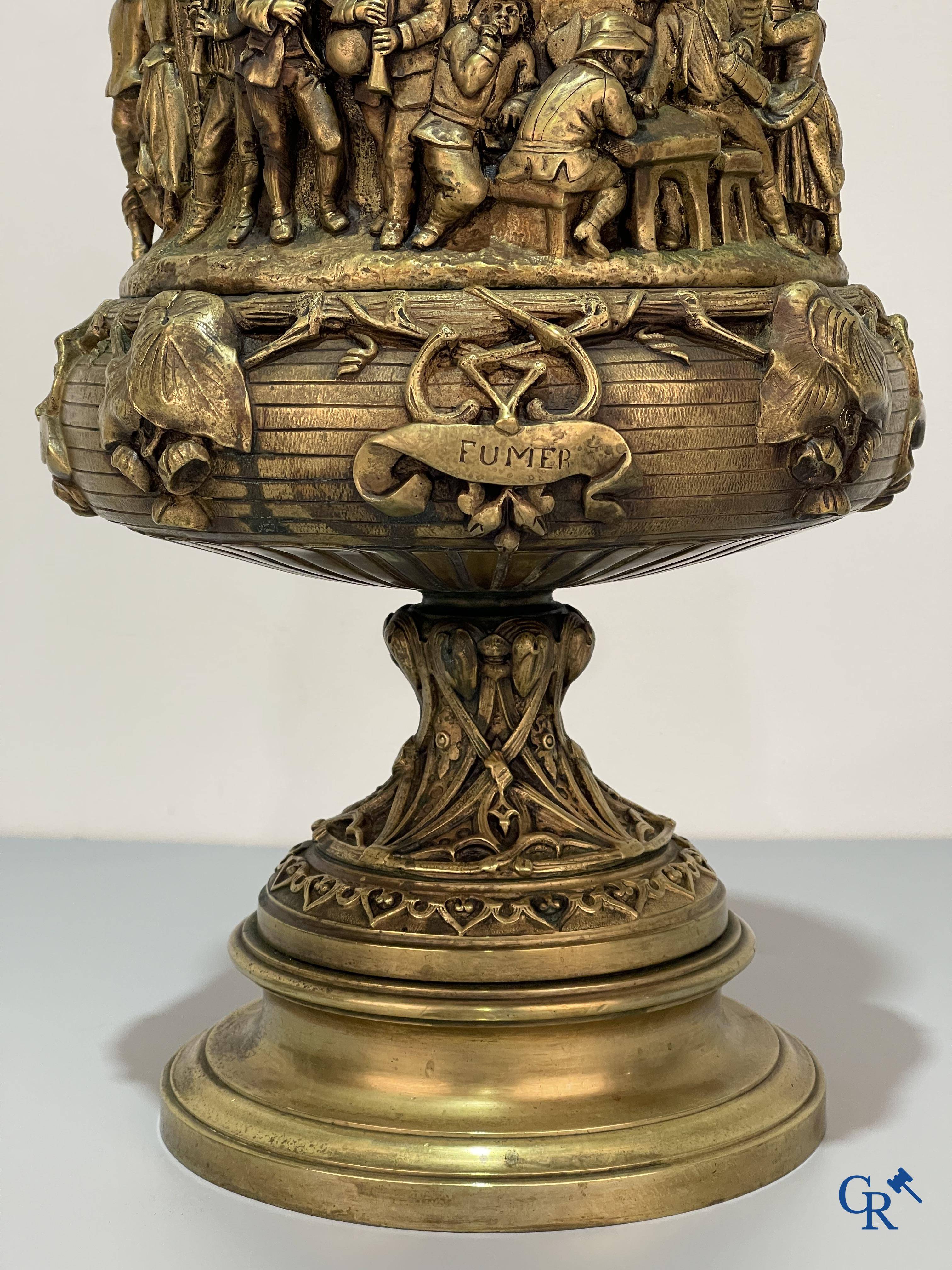 Un imposant pot à tabac en bronze finement travaillée avec les inscriptions "aimer, danser, fumer, boire".<br />
19ème siècle.