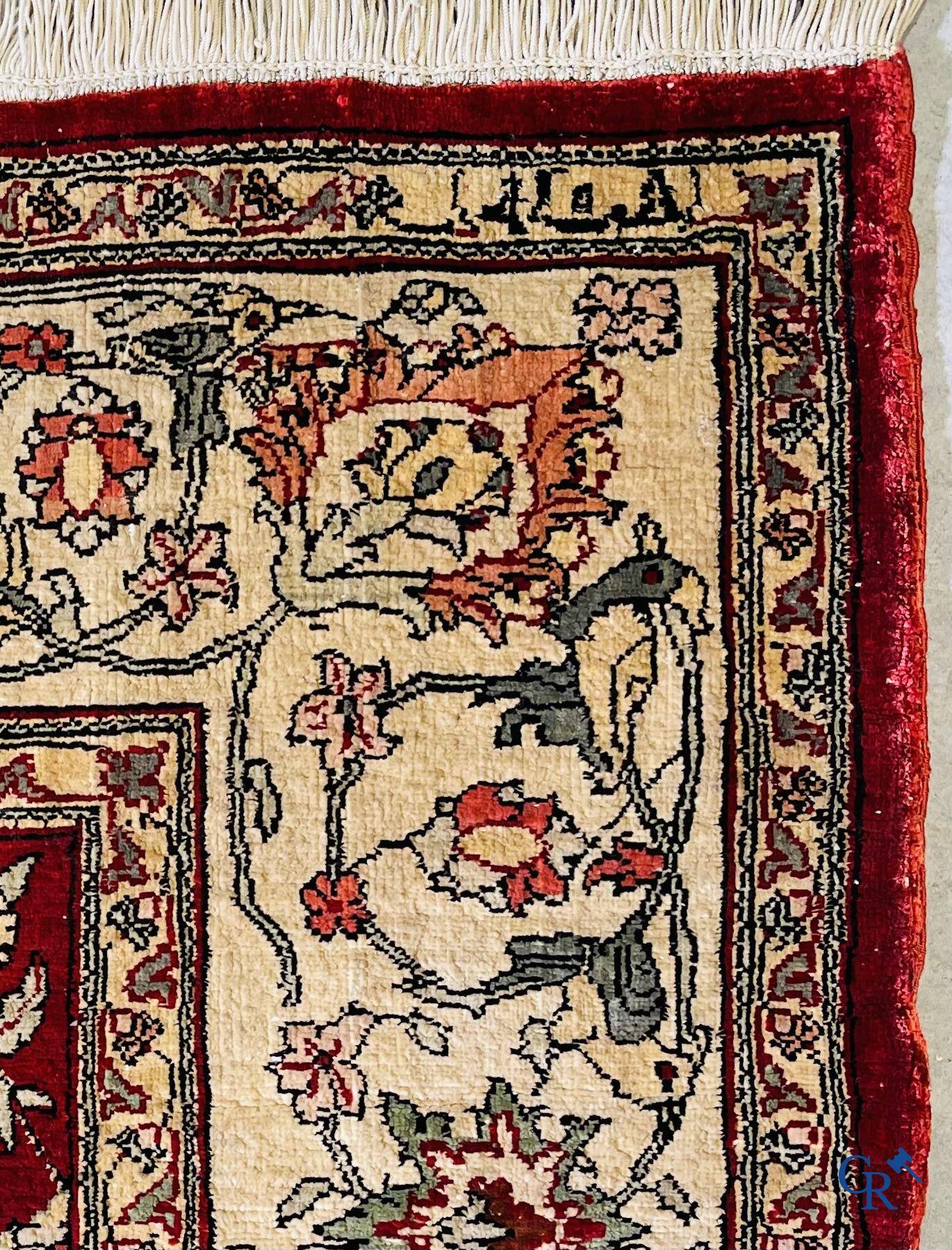 Oriental carpets, a hand-knotted carpet in silk with forest animals in a floral decor on a background in gold thread.