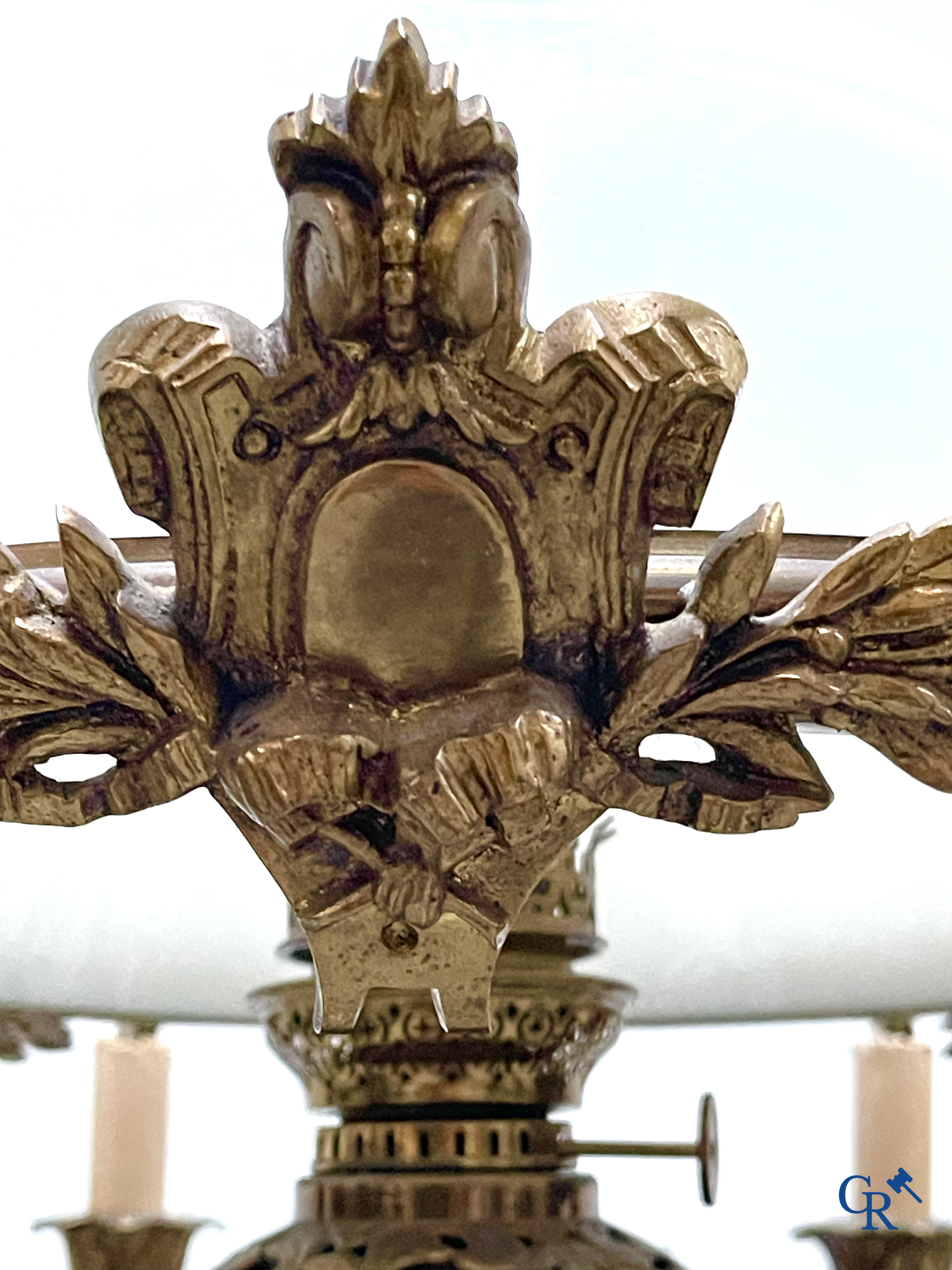 A lot of an imposing chandelier with 12 light points, a lamp belge with bronze frame and a fireplace piece.