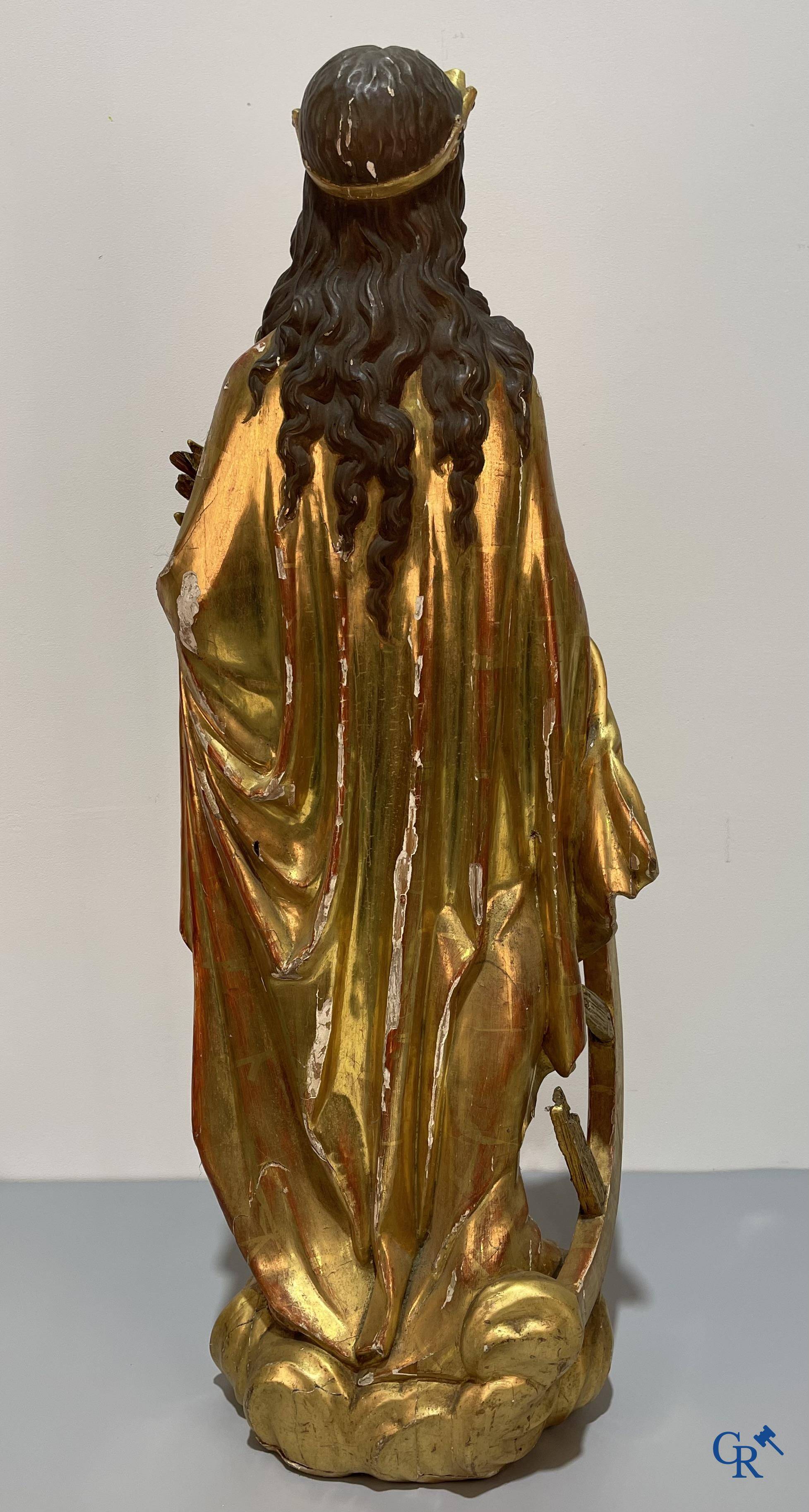 A large gilded and polychrome wooden statue of Saint Catherine of Alexandria.