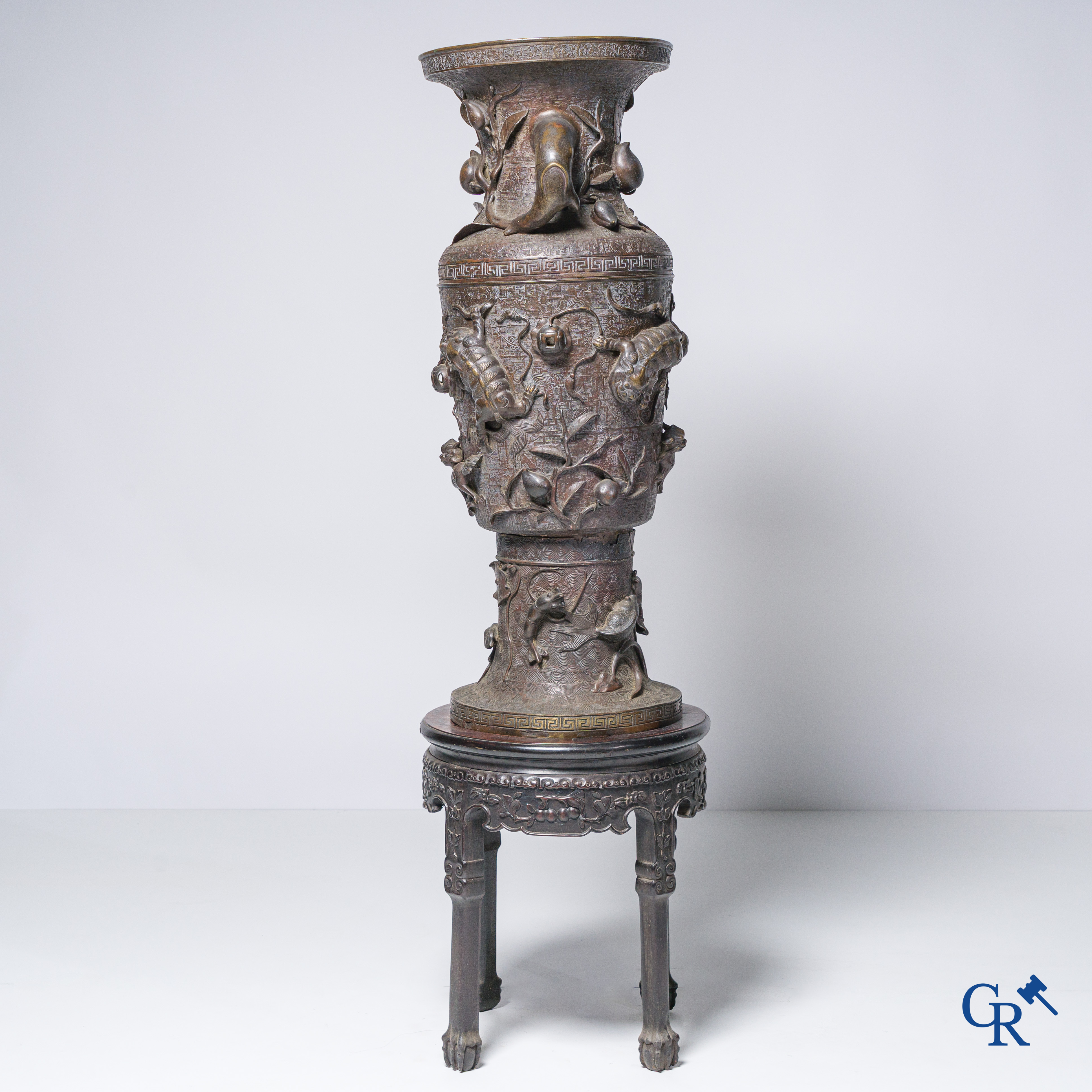 Aziatica, een imposante bronzen Chinese vaas op een sokkel in Chinees hardhout.