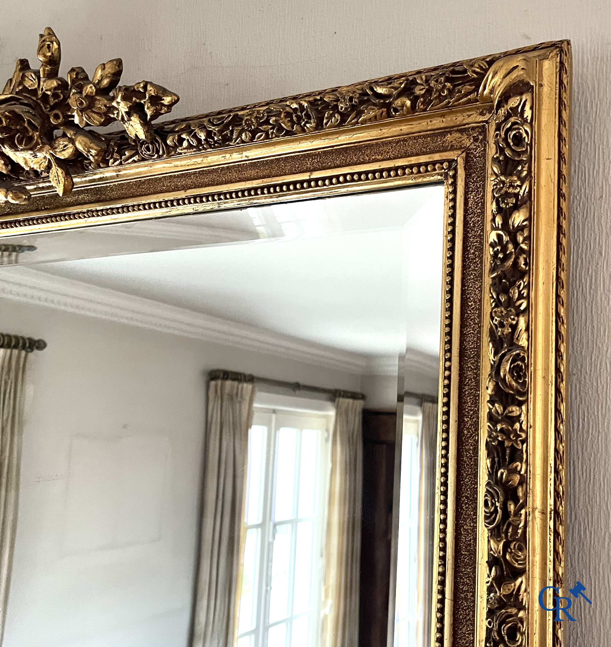 A large gilded fireplace mirror in LXVI style. Circa 1920.