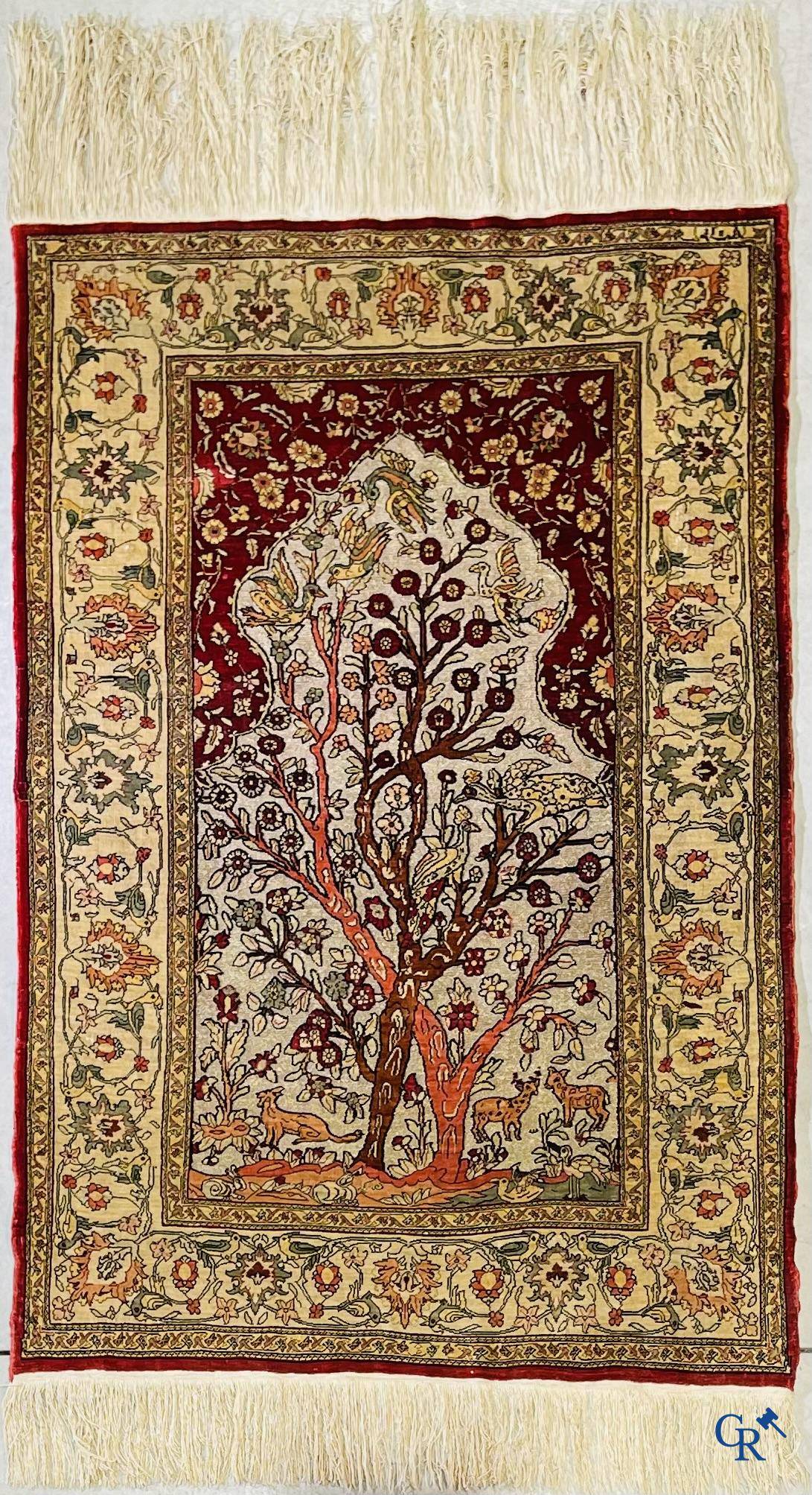 Oriental carpets, a hand-knotted carpet in silk with forest animals in a floral decor on a background in gold thread.