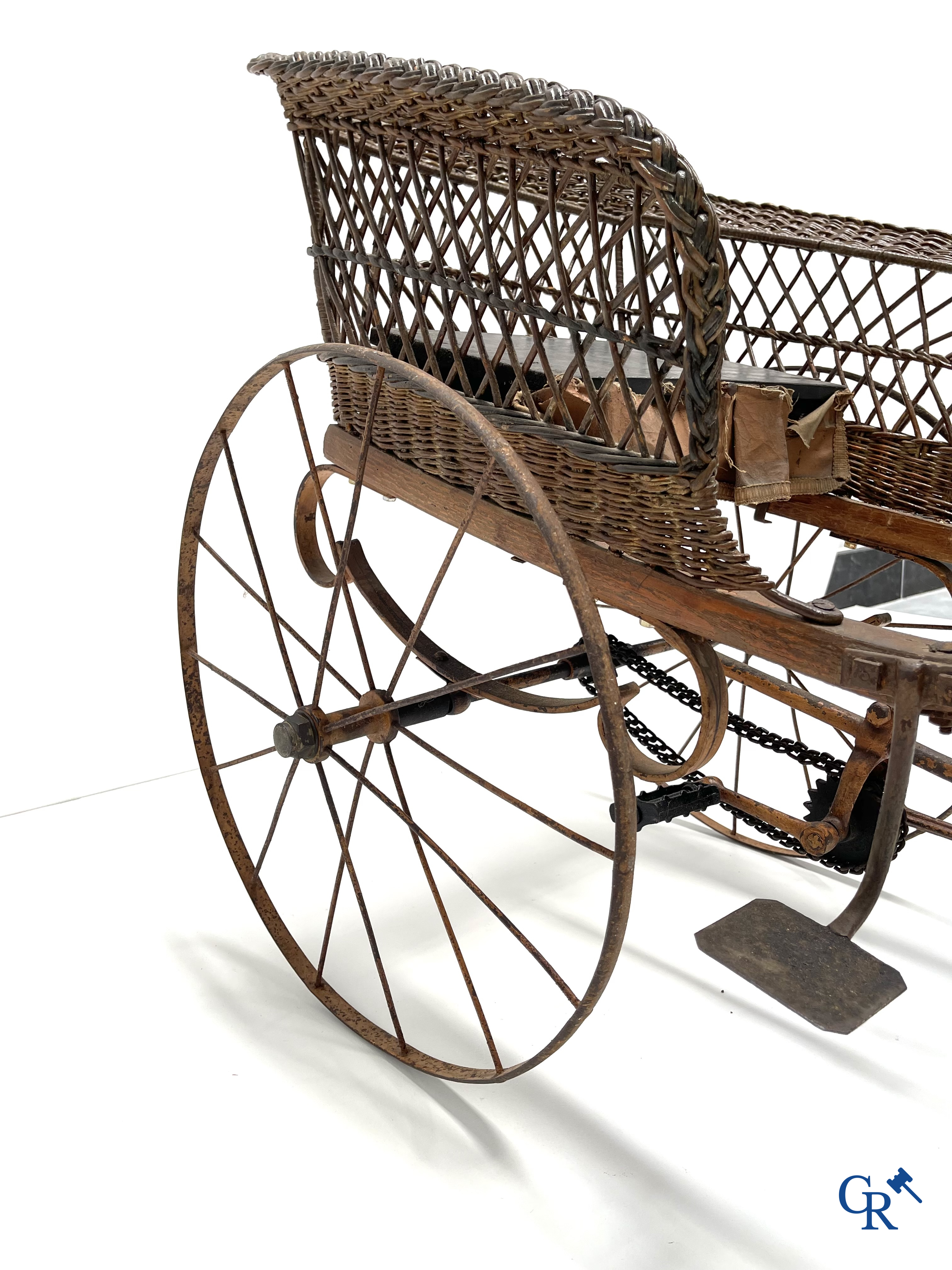 Zeldzame mechanische kinderkar in gevlochten riet en beschilderd metaal ontworpen door Peugeot. Circa 1900.