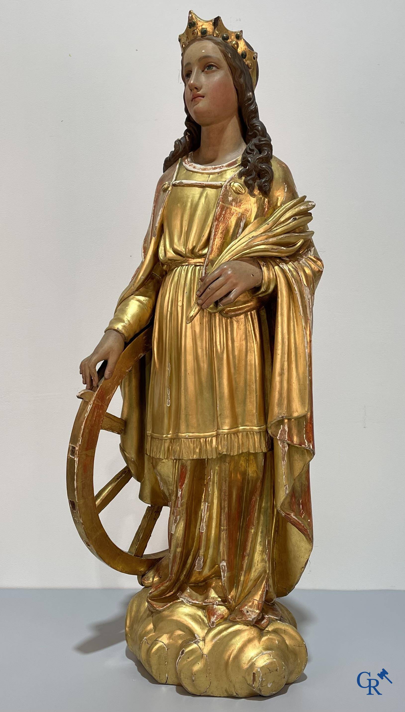 A large gilded and polychrome wooden statue of Saint Catherine of Alexandria.