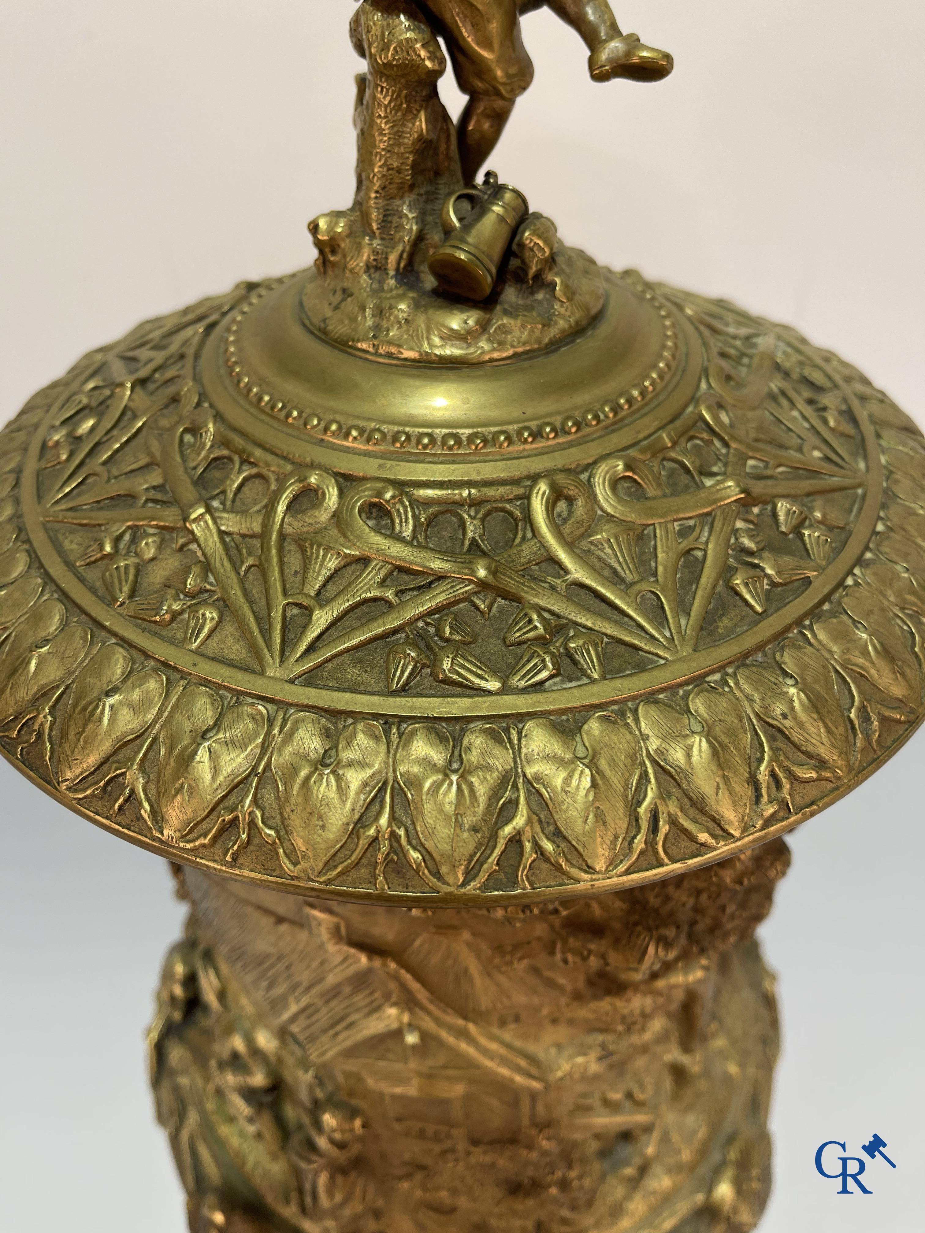 Un imposant pot à tabac en bronze finement travaillée avec les inscriptions "aimer, danser, fumer, boire".<br />
19ème siècle.