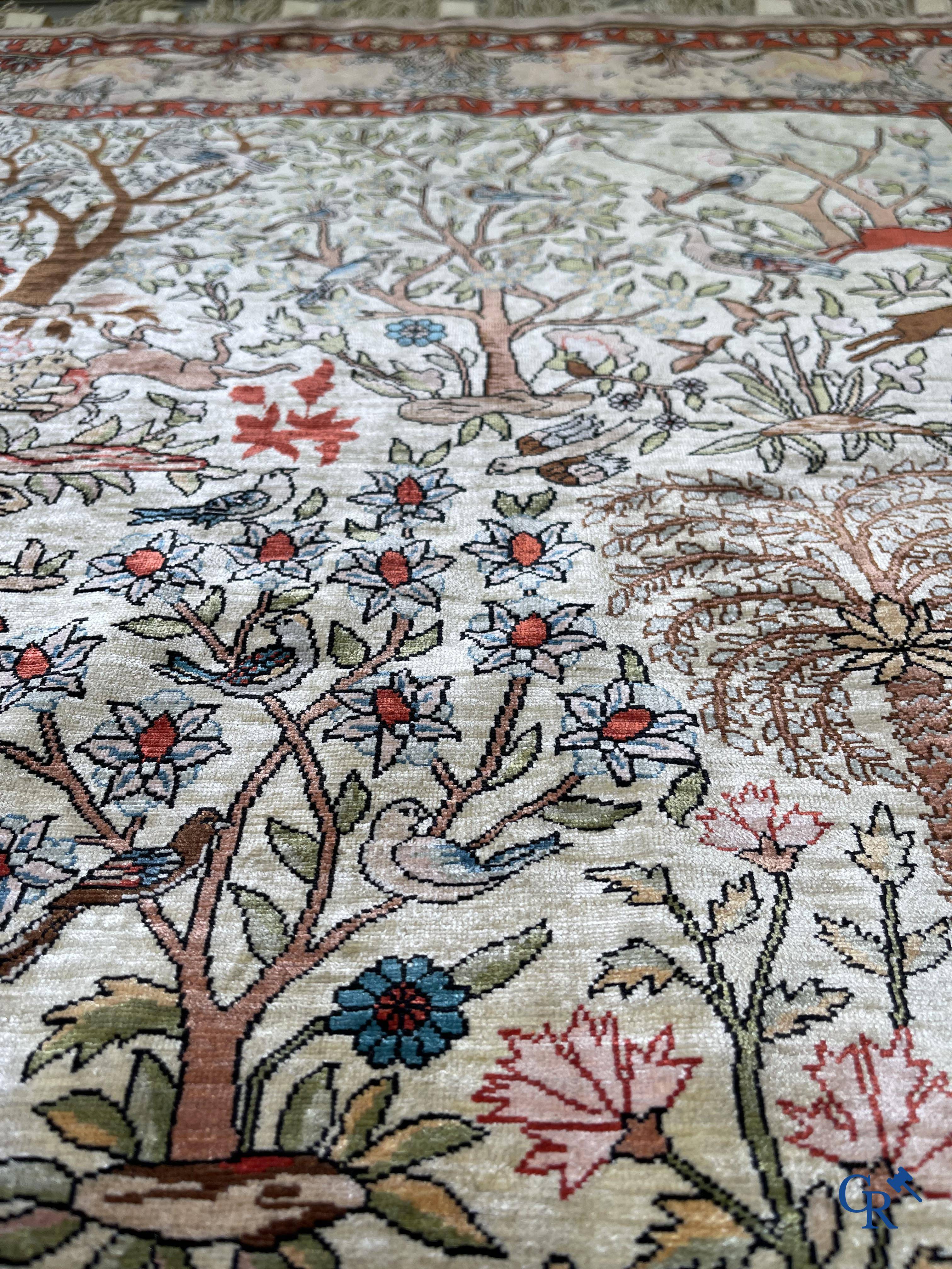 Oriental rugs, a fine hand-knotted silk tapestry with animals in a forest. Signed.