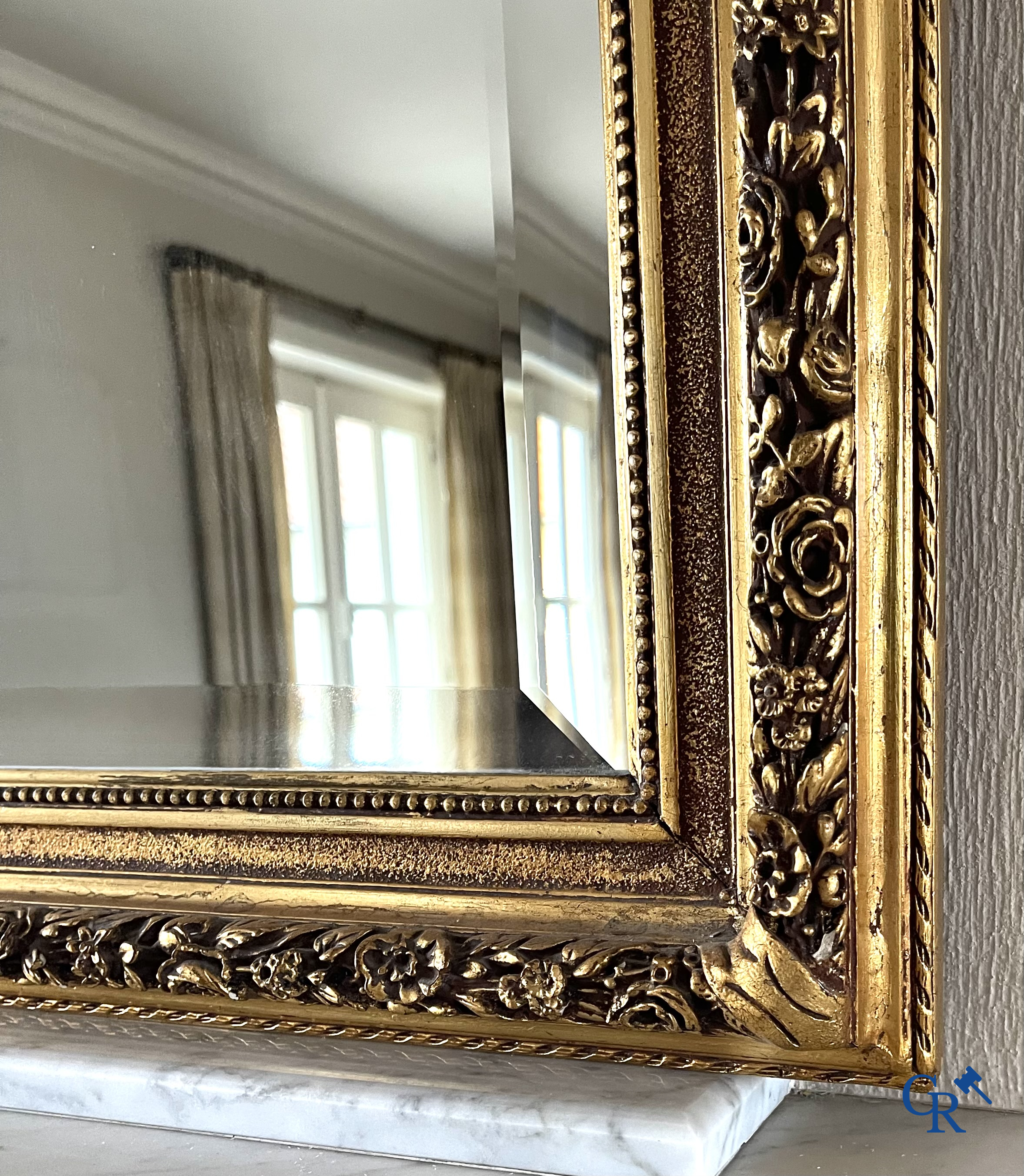 A large gilded fireplace mirror in LXVI style. Circa 1920.