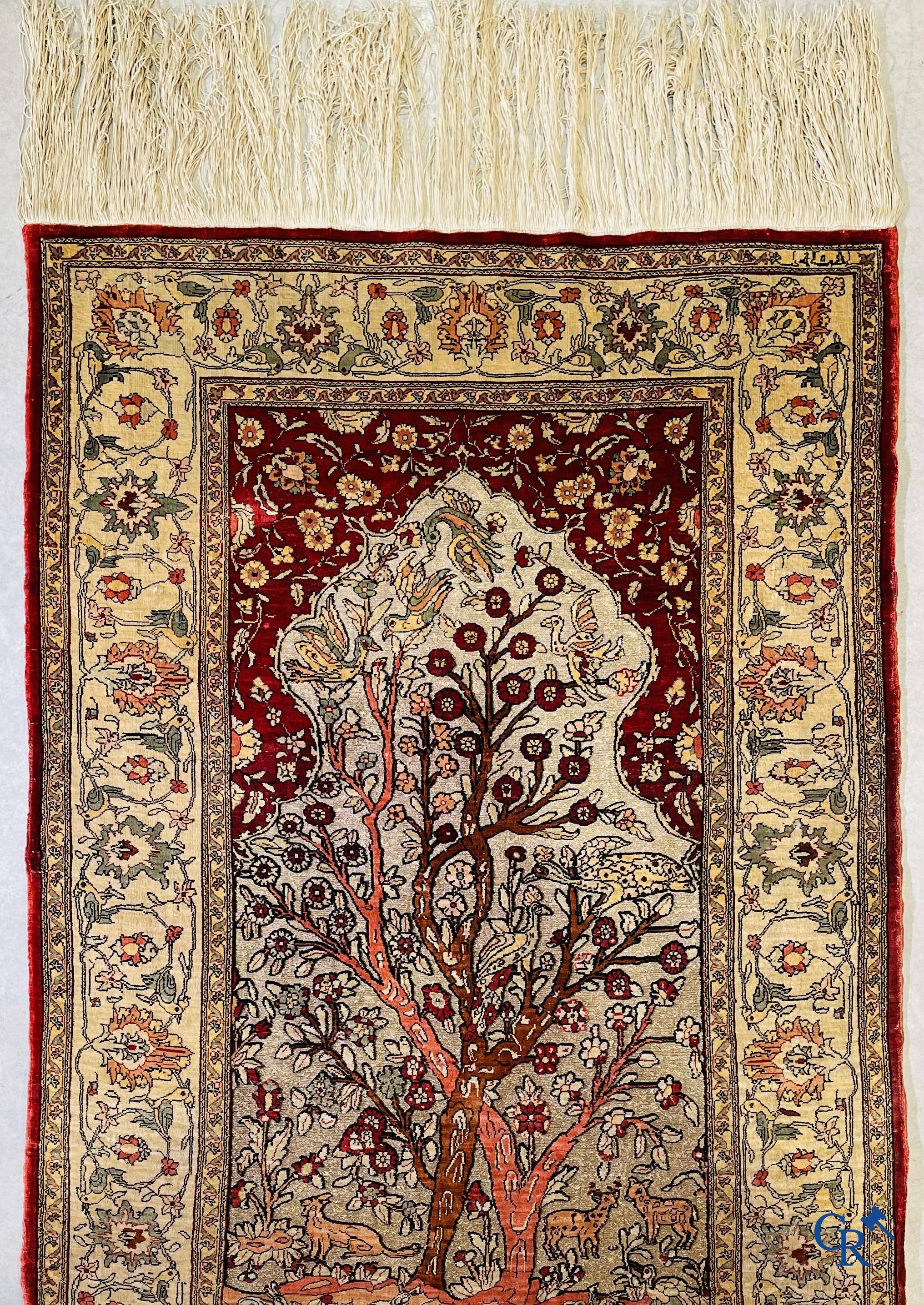 Oriental carpets, a hand-knotted carpet in silk with forest animals in a floral decor on a background in gold thread.