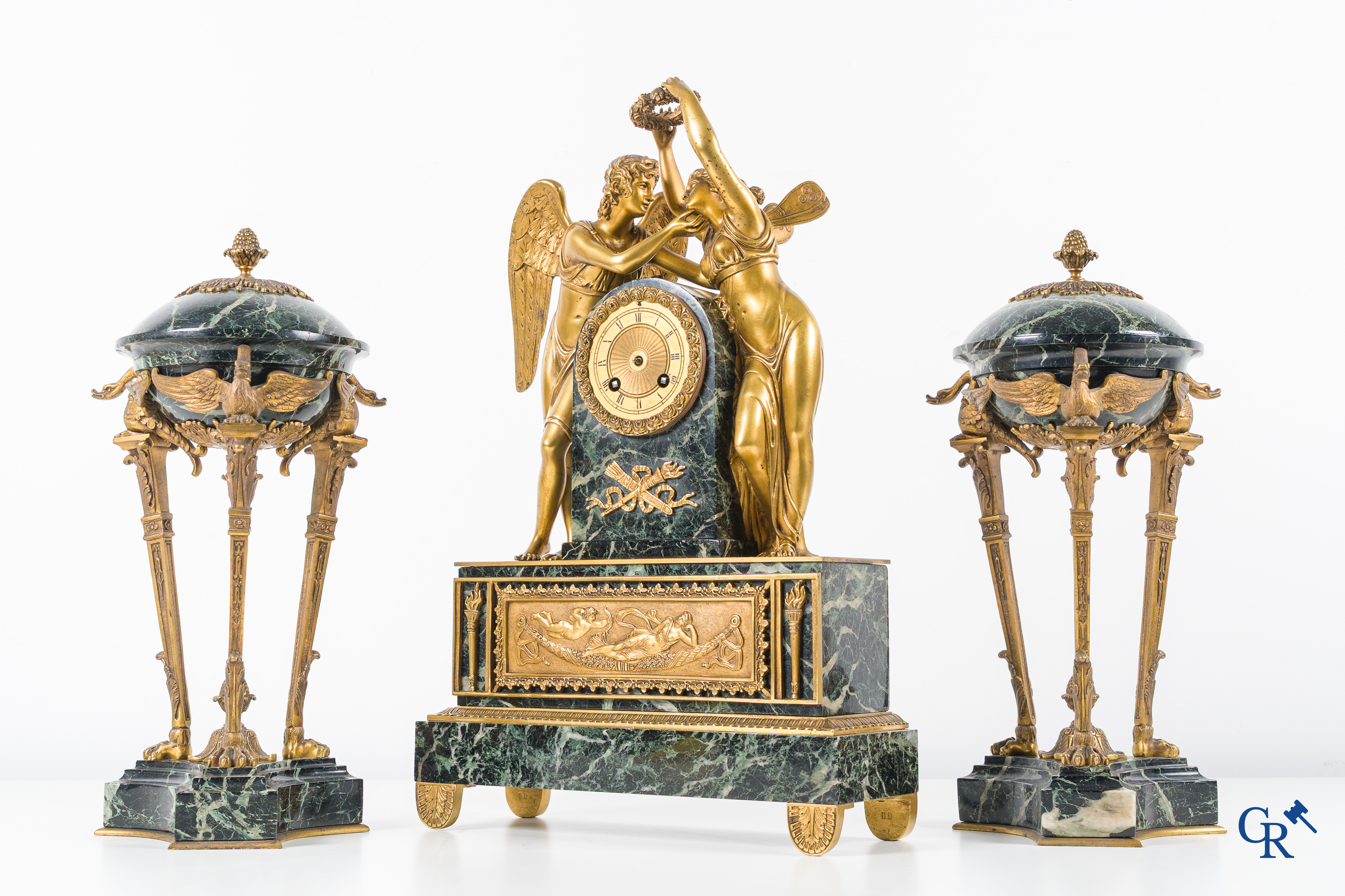 Een 3-delige schouwgarnituur in groen geaderde marmer en vergulde brons. Empire stijl. Circa 1900.