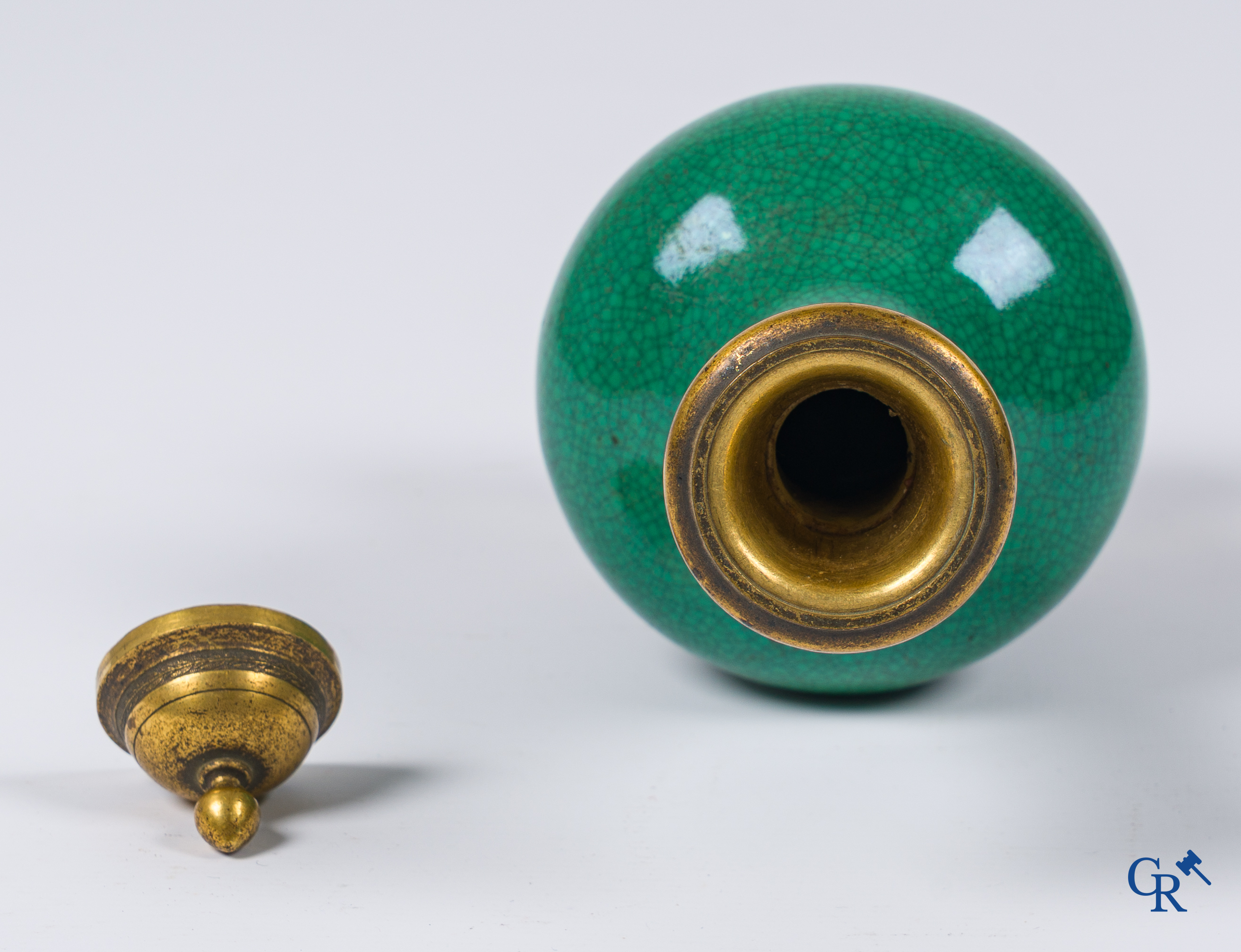 Asian Art. A porcelain vase in green crackle glaze with a bronze frame. 18th century.