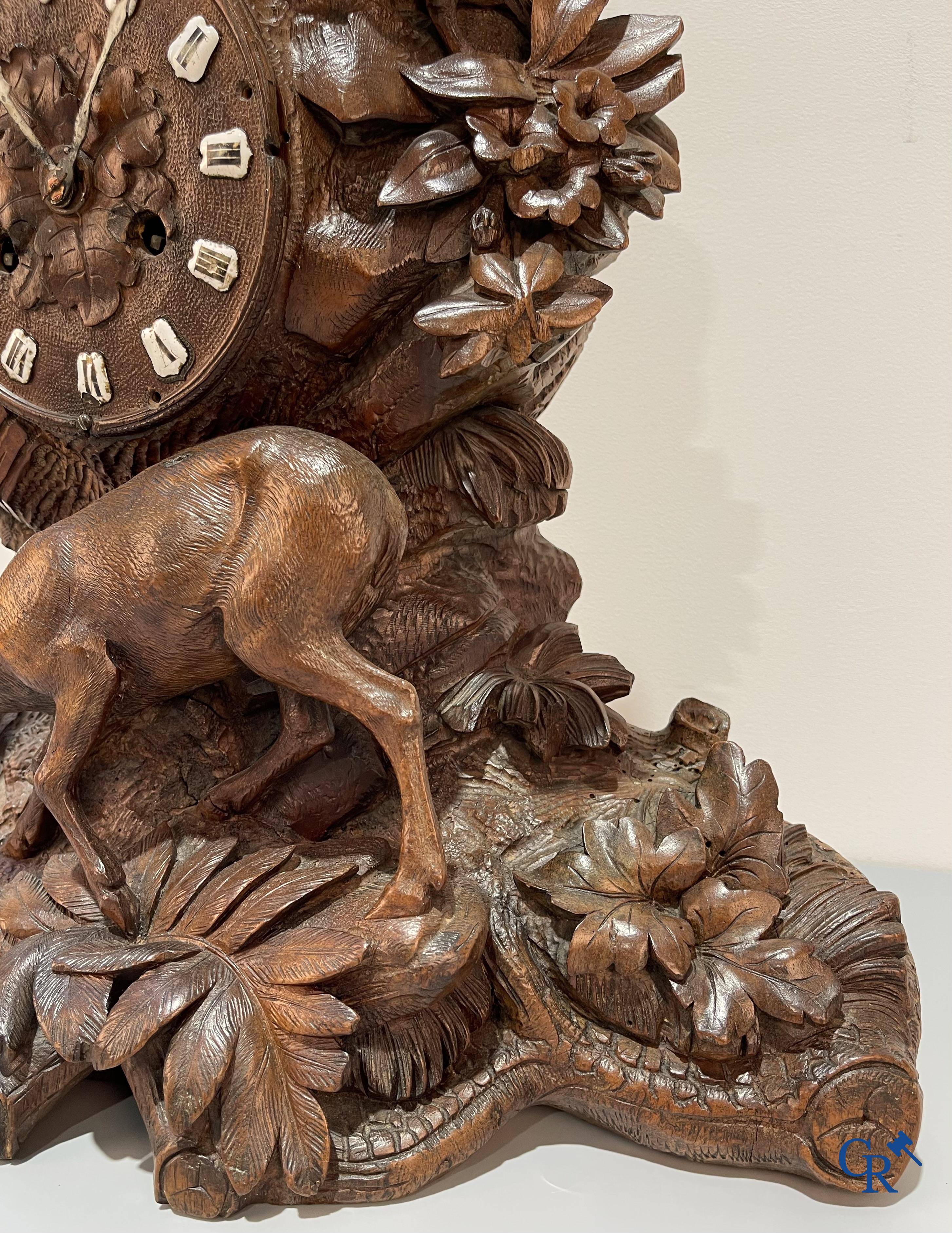 A wood sculpted Black Forest clock with deer in their flora. Germany, late 19th century.