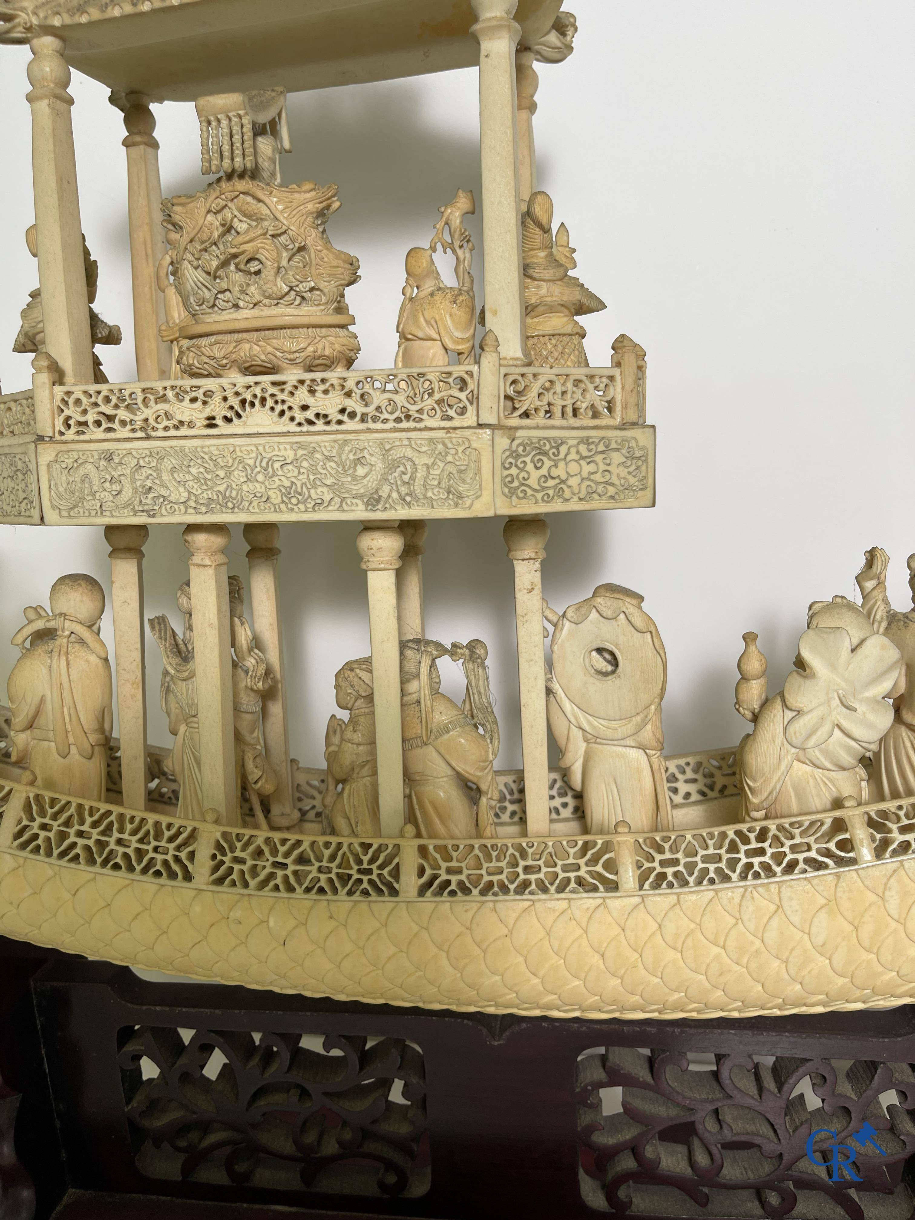 Asian Art: A large Chinese ivory dragon boat on a wooden pedestal. 19th century.